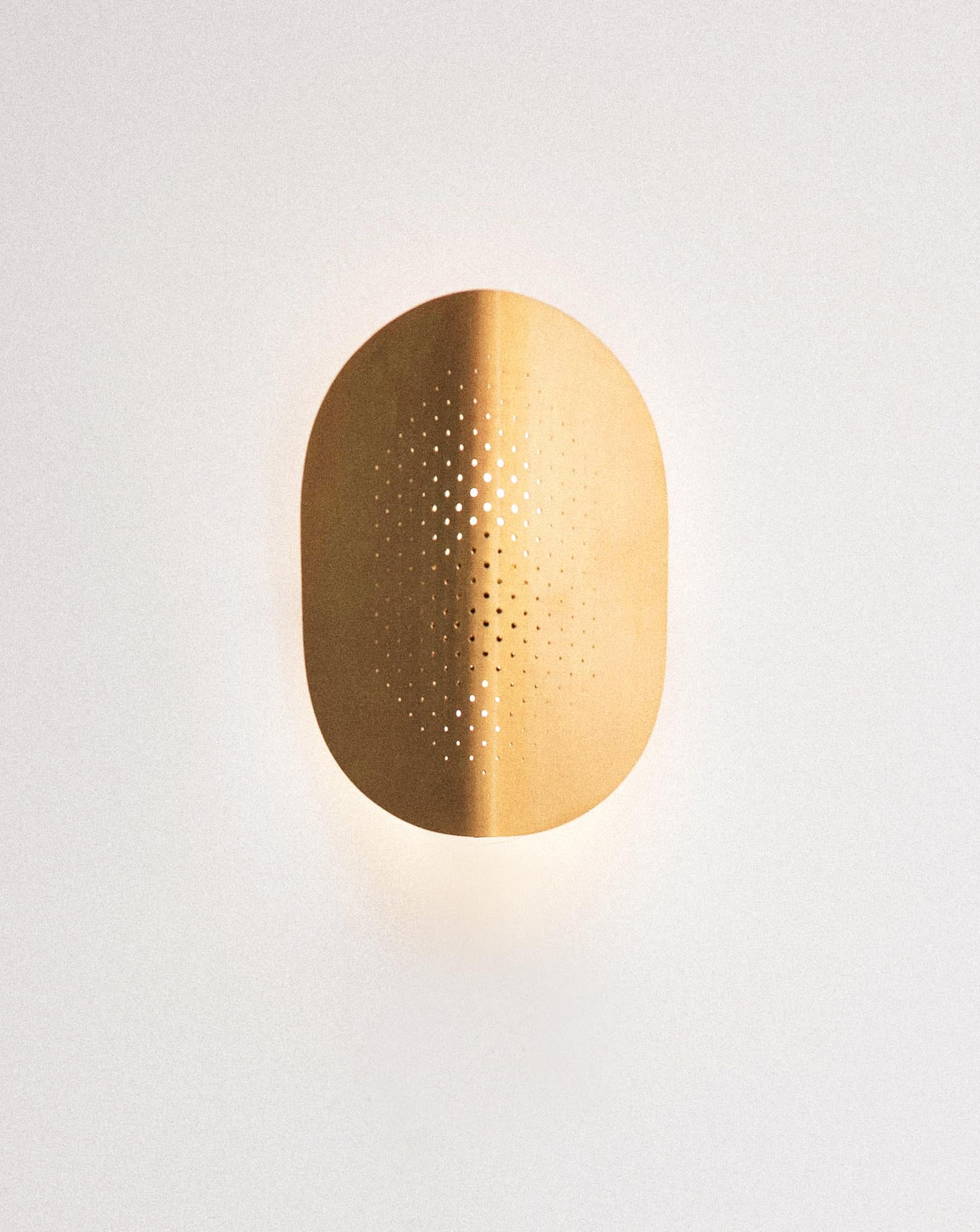 Moon applique by SB26
Dimensions : W 20 x D 10.5 x H 30 cm
Materials : Steel, brass gilded with pure gold

This wall lamp Moon, in the spirit of the range, reveals its graphic game by the light. The entire steel structure has a hematite finish