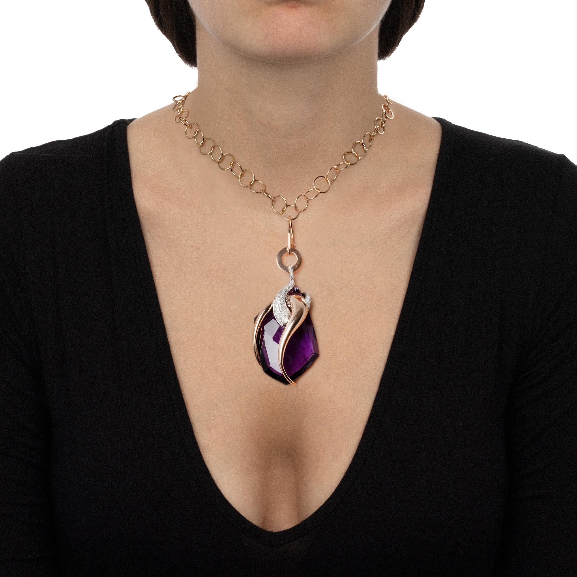 A handmade contemporary jewelery piece with a modern design, this pendant necklace is a dazzling fashion statement. The evocative charm of the central amethyst blends with the innovative design of the intertwined decoration blends with the embrace