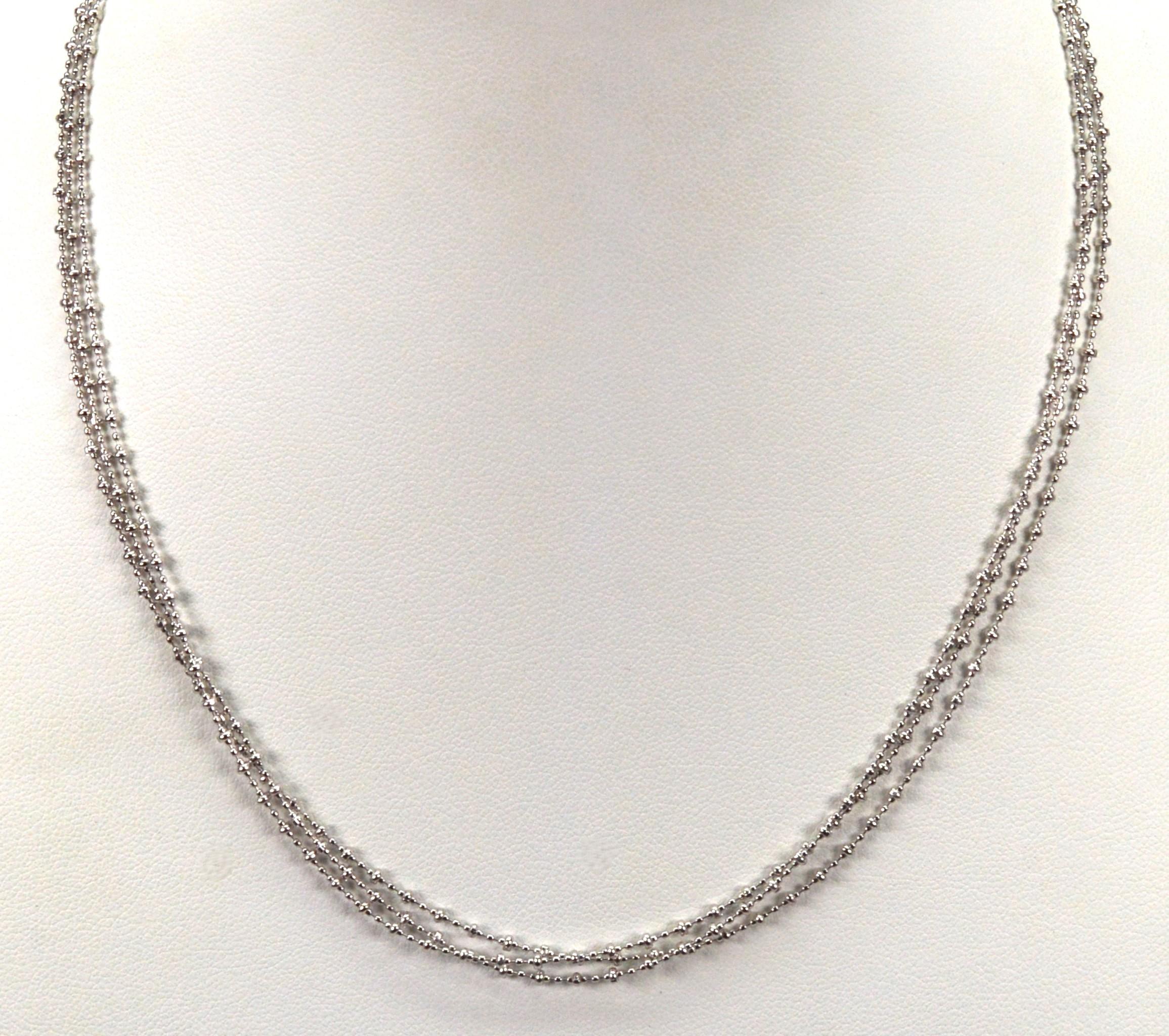 En or blanc 14 carats polyvalent, trois brins fluides de chaîne lune attrayante créent ce joli collier.
Dans une version plus courte de 15 pouces, les trois chaînes perlées sont de la même longueur et s'emboîtent un peu plus haut au niveau du col