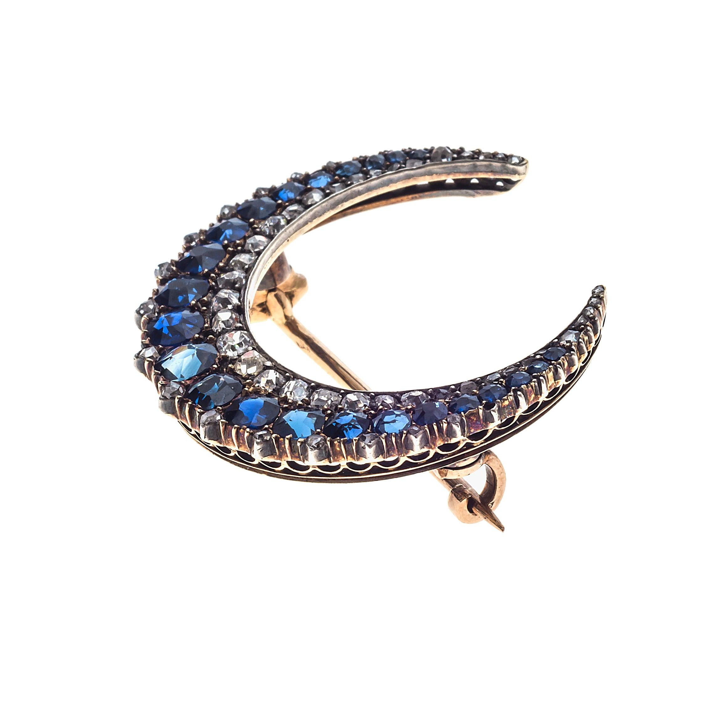 Very fine brooch of a waxing moon in form of a crescent set with natural sapphires and old cut and rose cut diamonds (0,57 ct). Twenty-three round facetted sapphires (1.95 ct) and fifty-two old cut diamonds (0.57 ct) mounted in silver backed in 18K