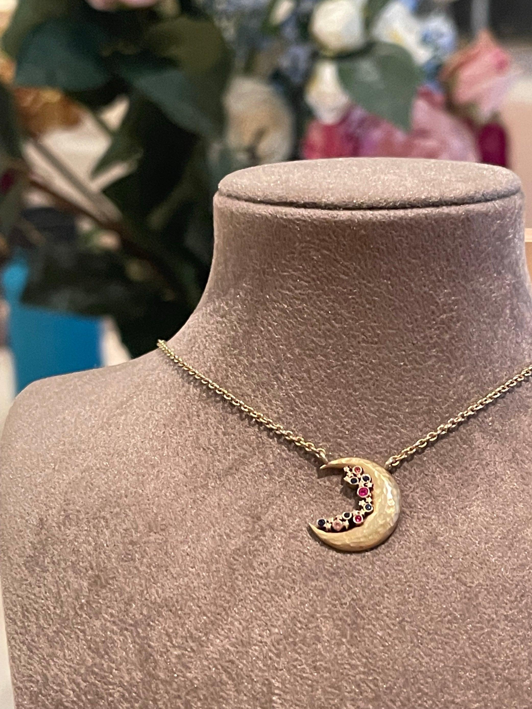 A stunning 14K gold moon crescent necklace with multicolor  sapphires and stars which is part of the Celeste constellation jewellery series. 

In Ancient Greece the moon was personified as the goddess Selene. Her parents were Titans Hyperion and