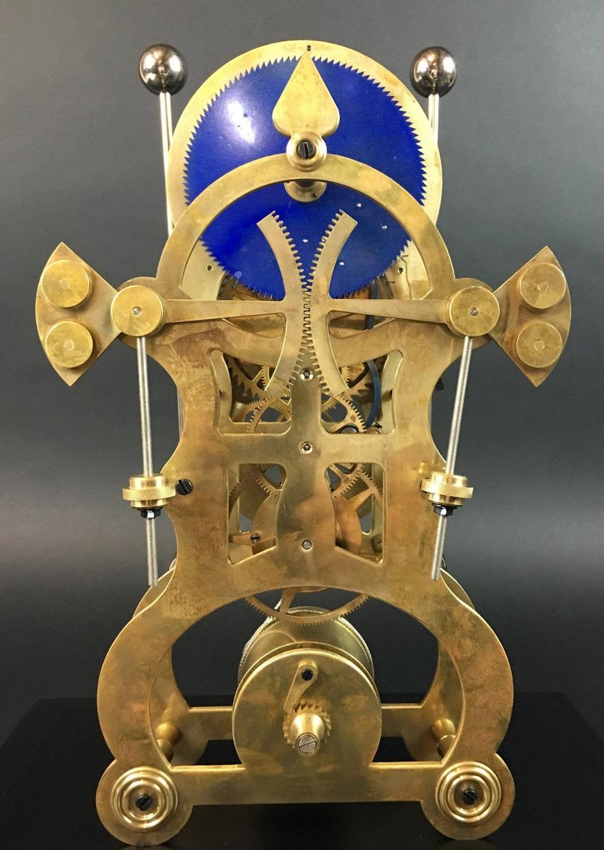 Attributed or Replica 
Moon dial grasshopper clock following John Harrison

A grasshopper clock following John Harrison, brass skeleton clock, 2 dials in white enamel, 2 counter-directional rod pendulums,
steel rope winding on winch. Solid wooden