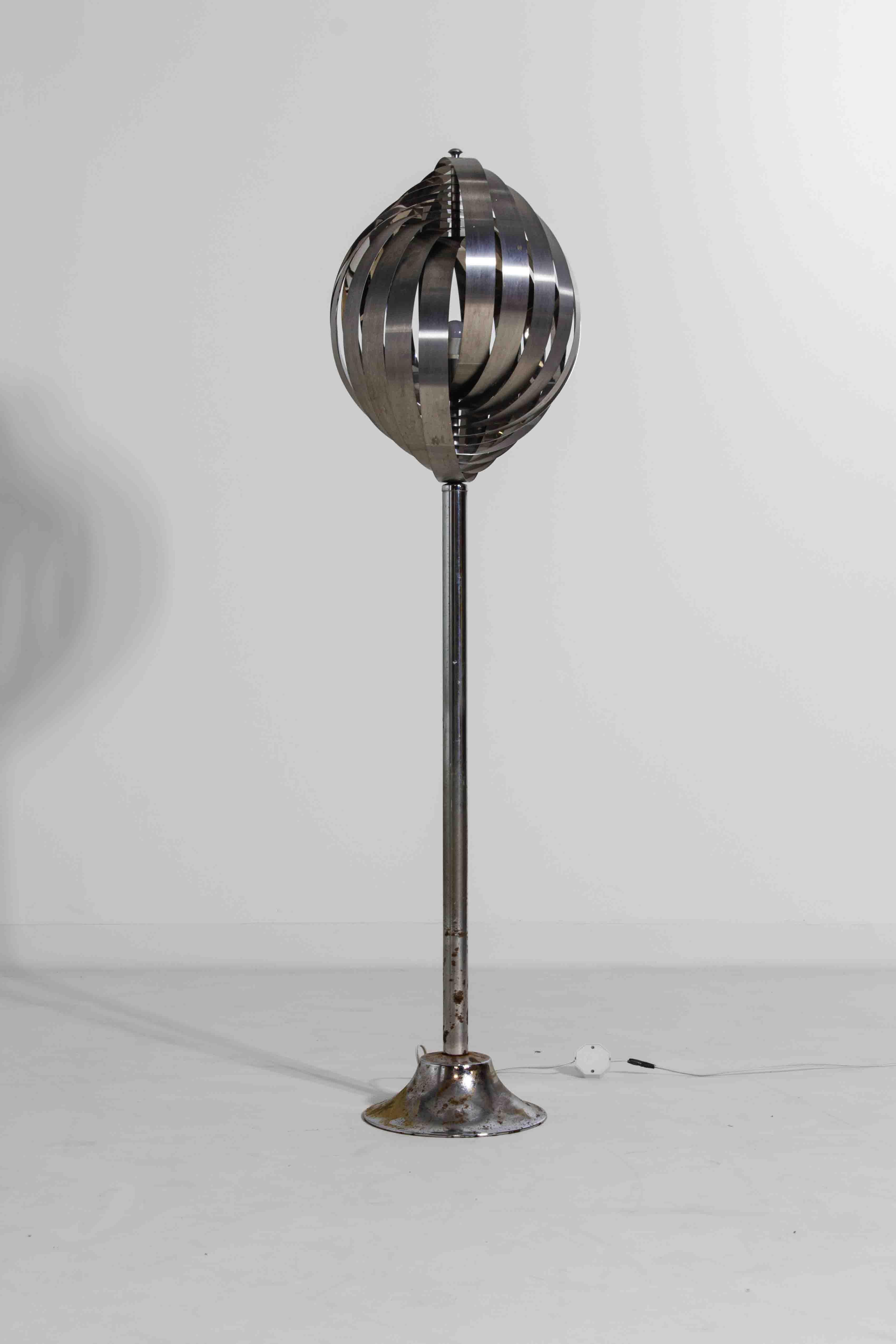 Striking sculptural floor lamp by French designer Henri Mathieu, made in the 1970s. The shade is constructed from a series of curved, hand-bent aluminium strips that form a spiral around the central bulb, creating a soft and layered light effect.