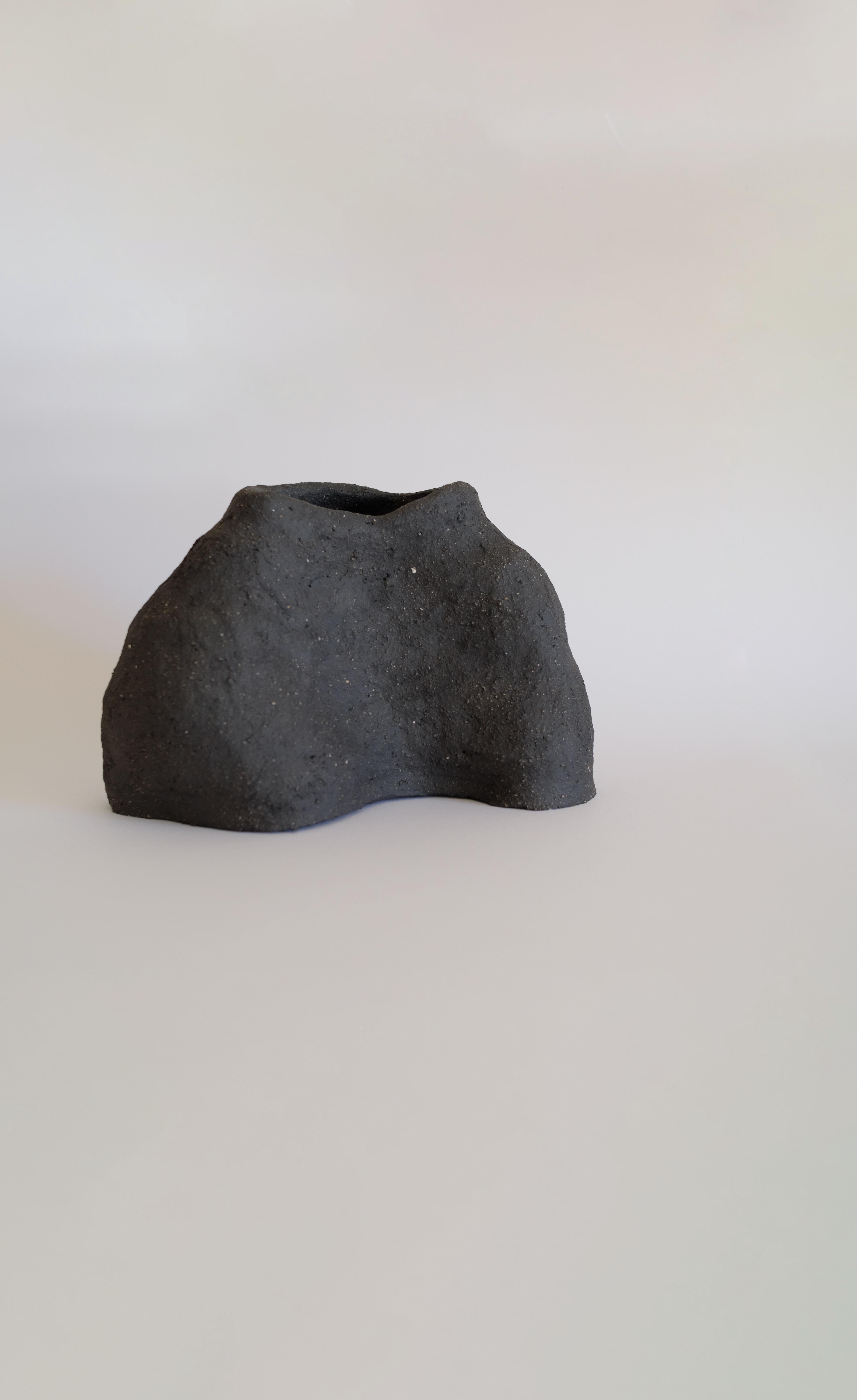 Moon Granite II vase by Sophie Parachey
Dimensions: W 17 x D 20 x H 30 cm
Materials: Black textured stoneware (large chamotte).

Inspired by extended stays in Central America, Sophie Parachey’s work questions transformation, the antagonism