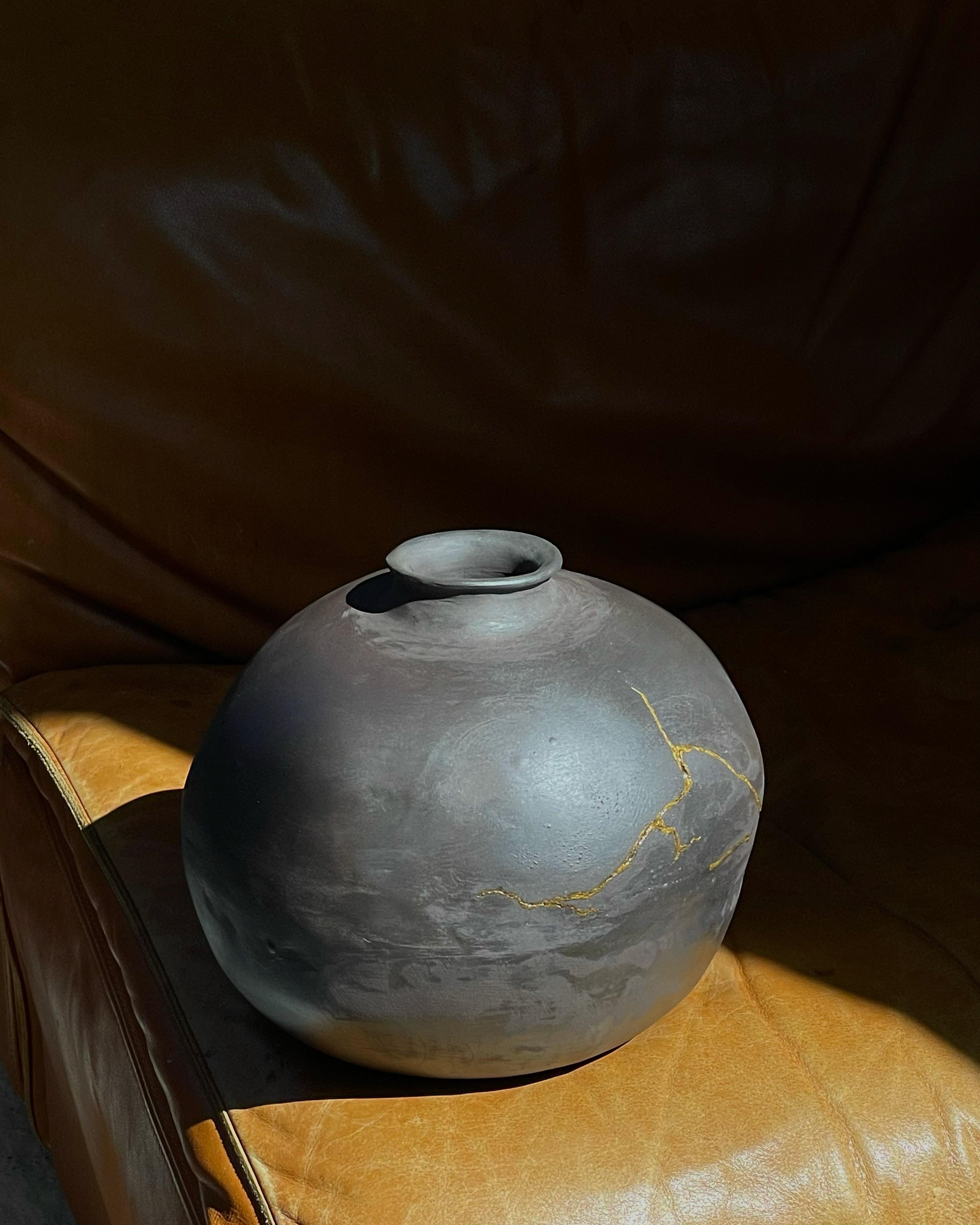 Vaso Moon Jar in ossidiana di Solem Ceramics
Dimensioni: Ø 42 x H. 42 cm.
Materiali: Gres nero, essenza oro.
Questo vaso Jar è disponibile anche nella finitura Raw.

Il lavoro di Solem si basa sui ricordi dell'architettura e della comunità del