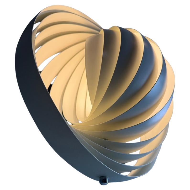Designed in 1960, the Moon represents one of Verner Panton’s earliest designs in lighting. The iconic pendant is characterized by its fan-like design with ten ring-shaped lamellae perfectly positioned to provide a soft, ambient and glare-free light.