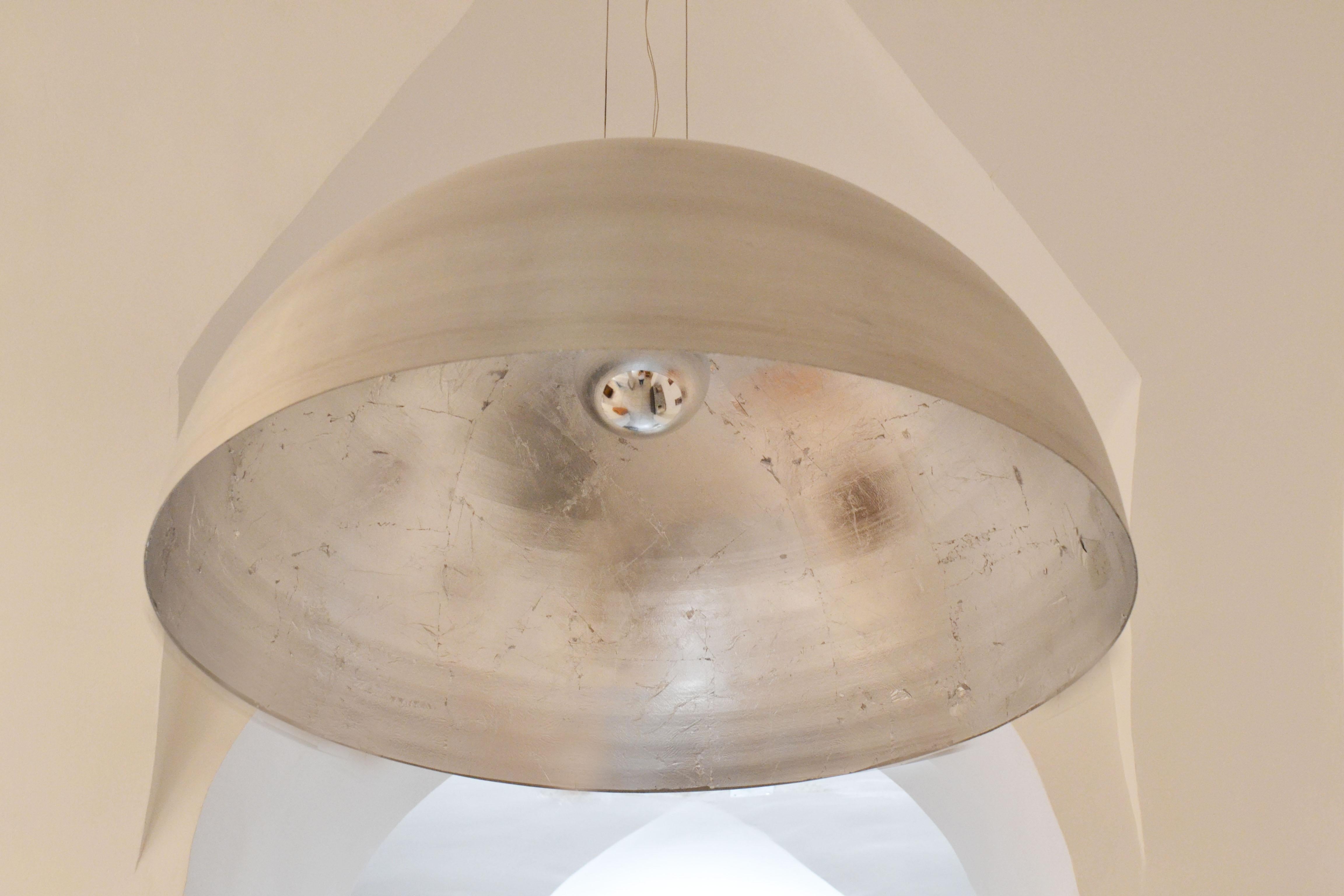 'Lámpara Luna' or 'Moon Lamp' is a large circular ceiling pendant or chandelier by the Spanish Design Studio Element&Co.

Its interior is lined with hand laid silver leaf which reflects the light and diffuses a mysterious glow.

Its body is