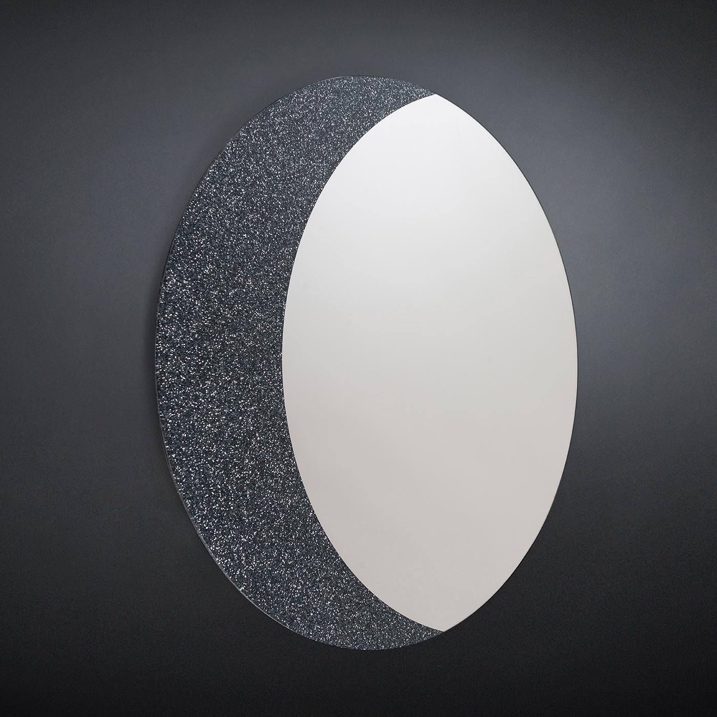 Designed by Giorgio Ragazzini, this mirror celebrates our satellite as seen when it raises. The round shape of the piece has a curved frame on one side contrasting in color and texture with the mirrored glass to create a poetic image of strong