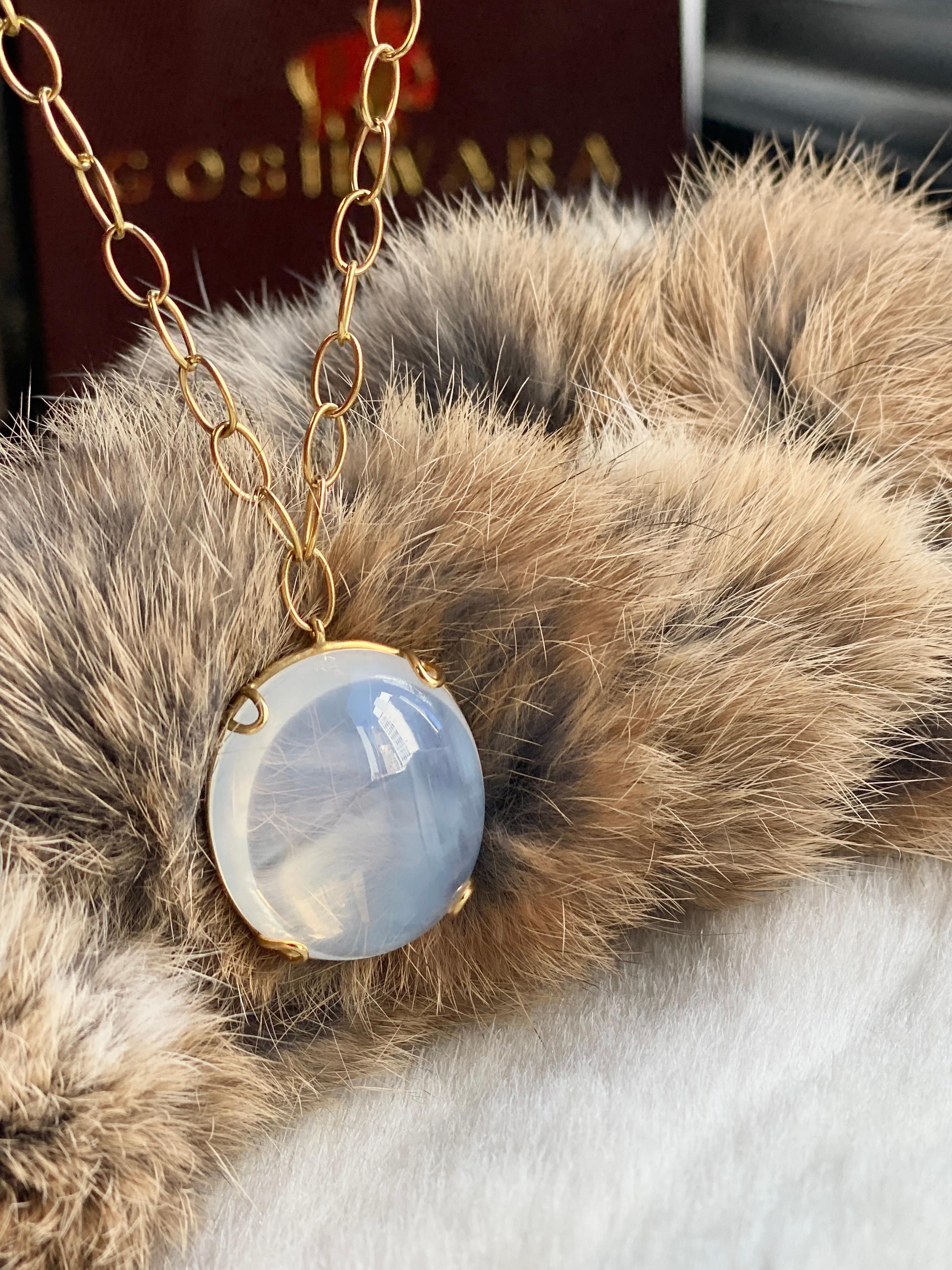 Questo ciondolo mette in evidenza un luminoso quarzo lunare ovale cabochon, che irradia un bagliore morbido ed etereo. Incastonata nell'oro giallo lucido 18 carati, la superficie liscia della pietra cattura la luce con un fascino sottile e onirico.