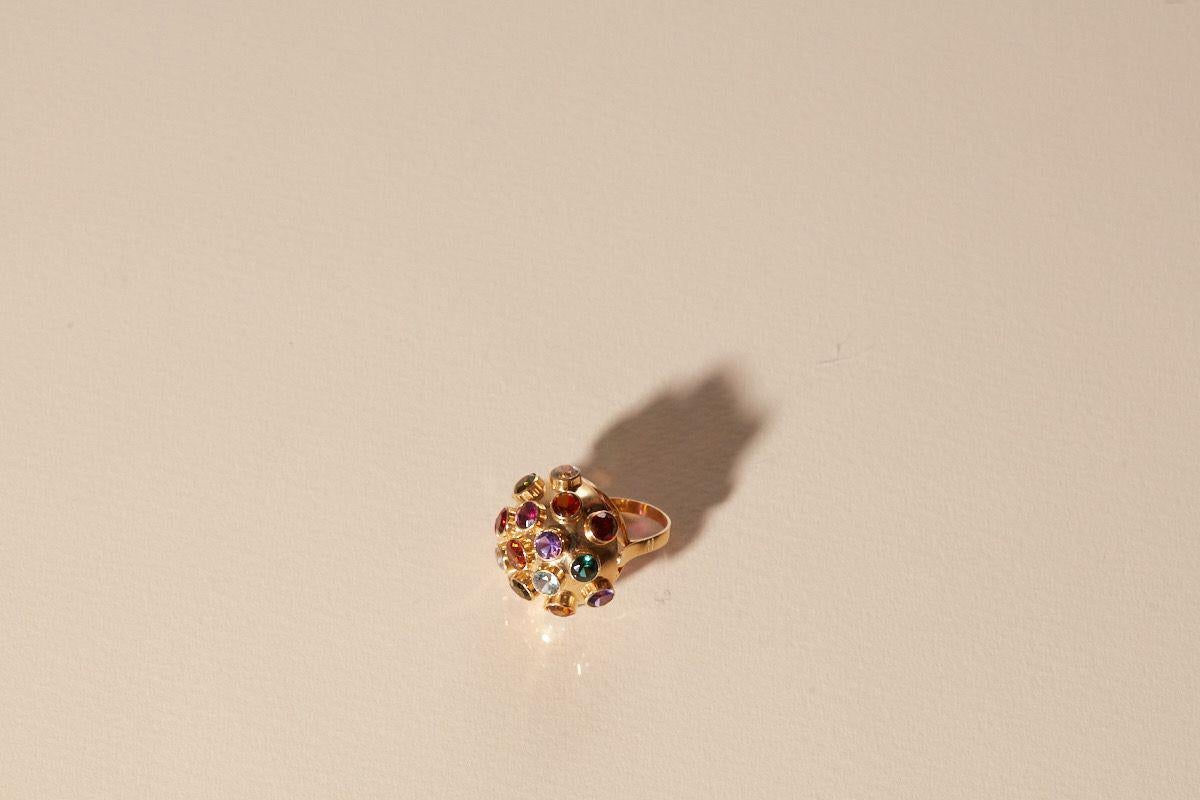 Is a solid 18k gold ring made by 14 grams modern ring with Sapphires from all colors cocktail piece.