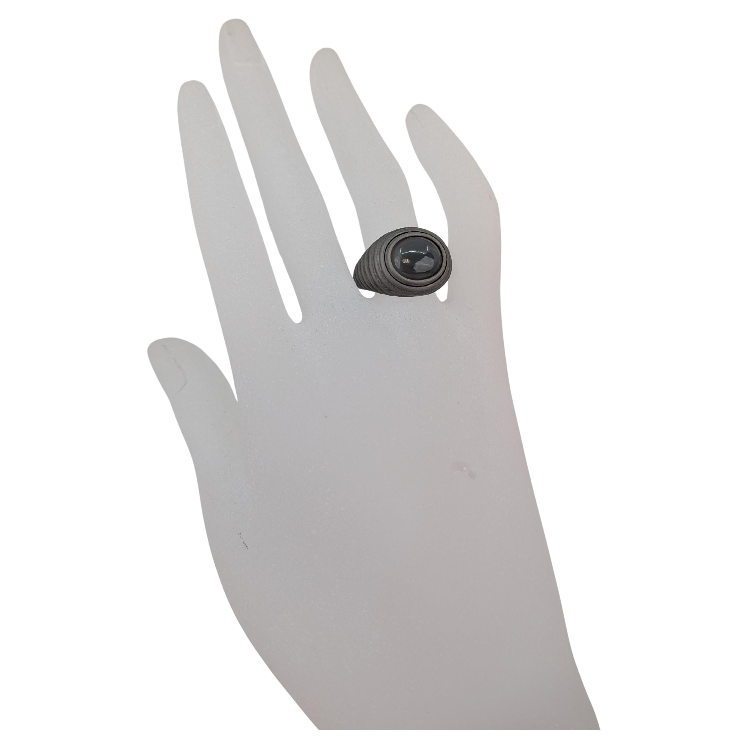 Grey moonstone cabochon ring in grey titanium and 18k 750 white gold featuring a sculptural contemporary MXHM design with a natural gemstone and matte layered contours. The piece is from the archive collection which is inspired by Maximilian's