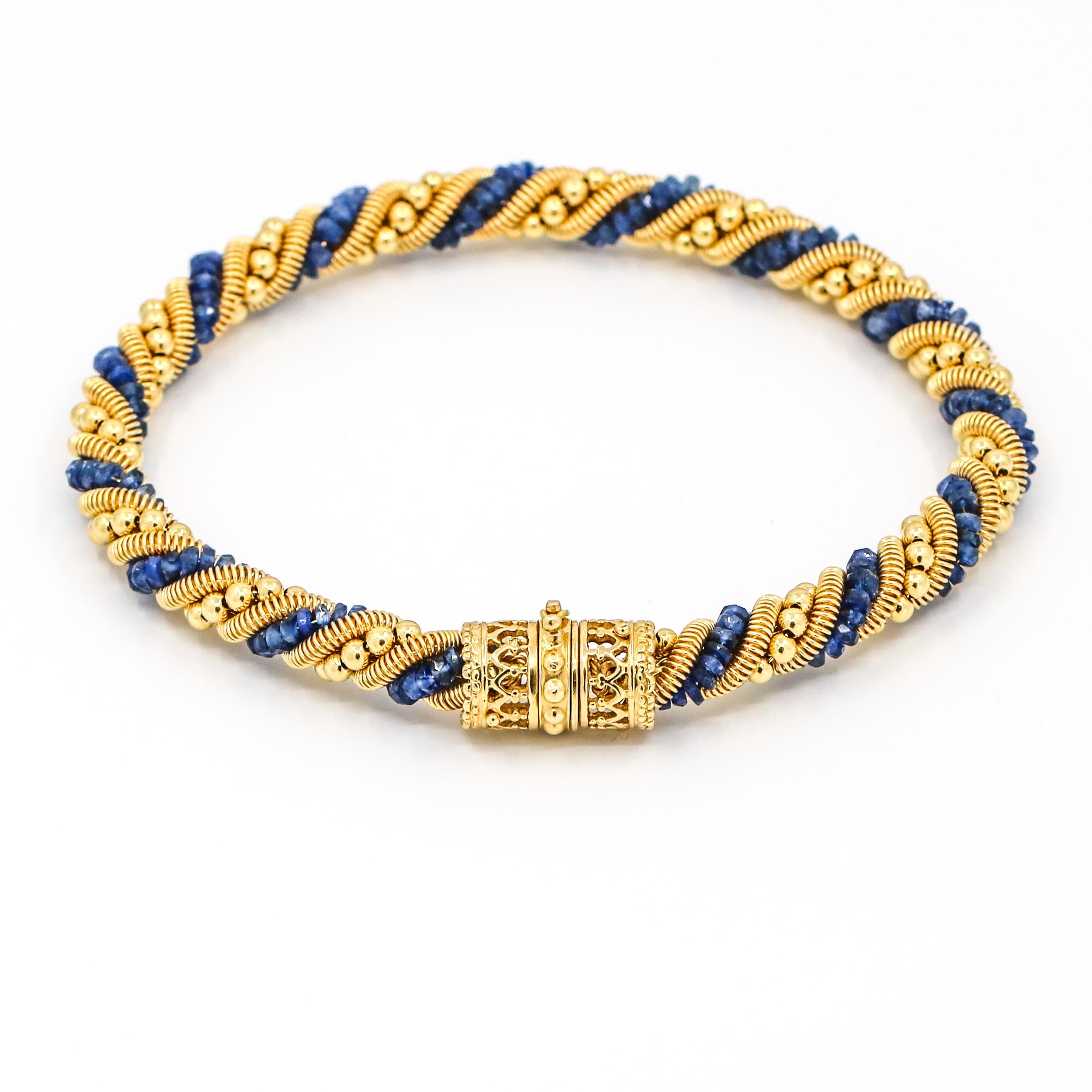 Moonlight twisted flexible chain bracelet in 18-karat yellow gold with blue sapphires. The rope chain is made out of gold beads, sapphire beads, and a gold coil. Slide clasp with hidden safety. Signed Moonlight. Made in Italy. 

Size, Medium
Length,
