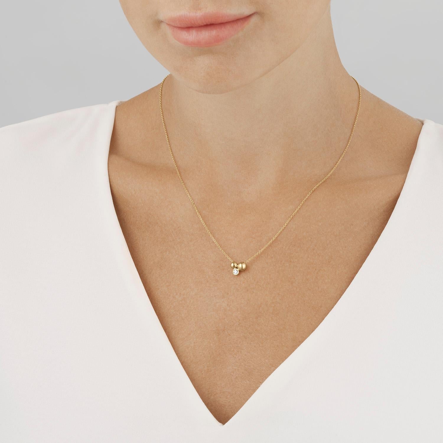 With its two beads of 18 karat recycled yellow gold clustered together with a single brilliant cut diamond, this pendant is an understated but luxurious piece of jewellery. Combining classic elegance with contemporary sophistication, the pendant