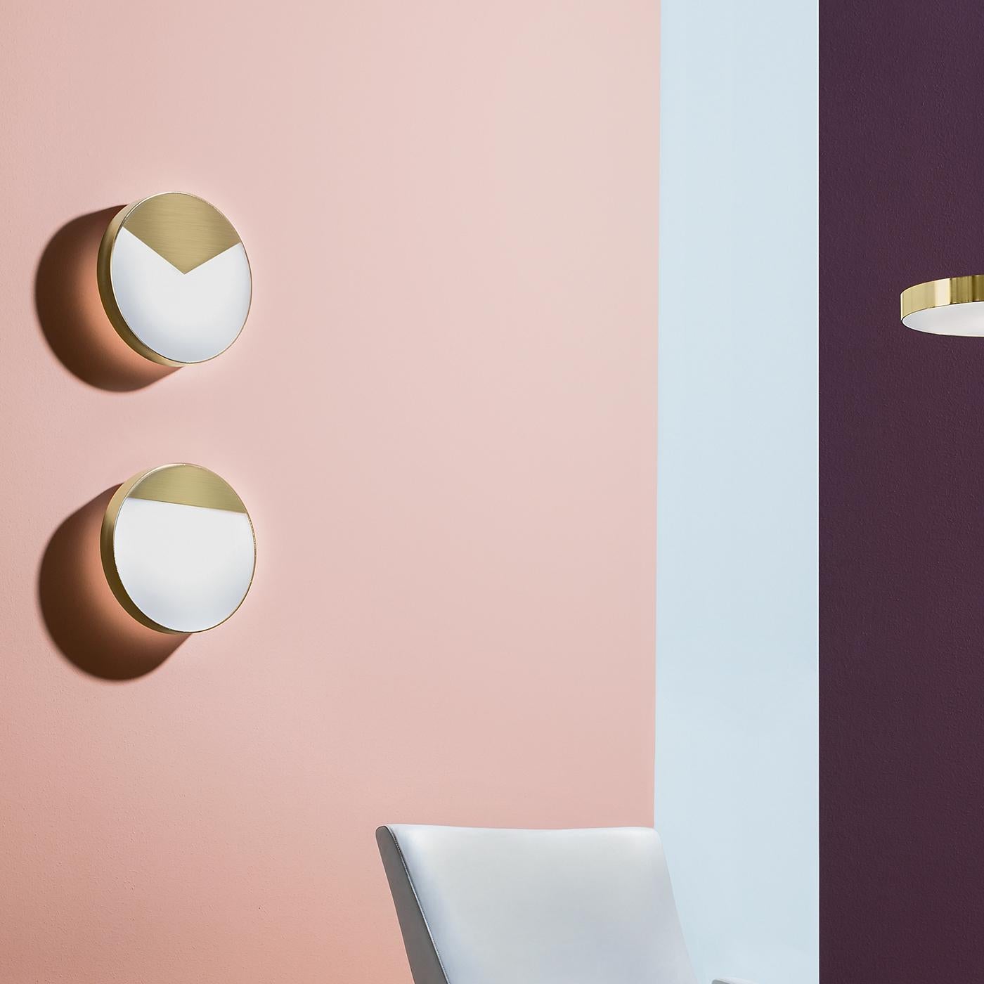 This exquisite metal sconce by Matteo Zorzenoni is an exercise in geometric and elegant lines. Attached to the circular brass structure by means of magnets, a small, triangular metal sheet with a satin brass finish adds a sophisticated accent