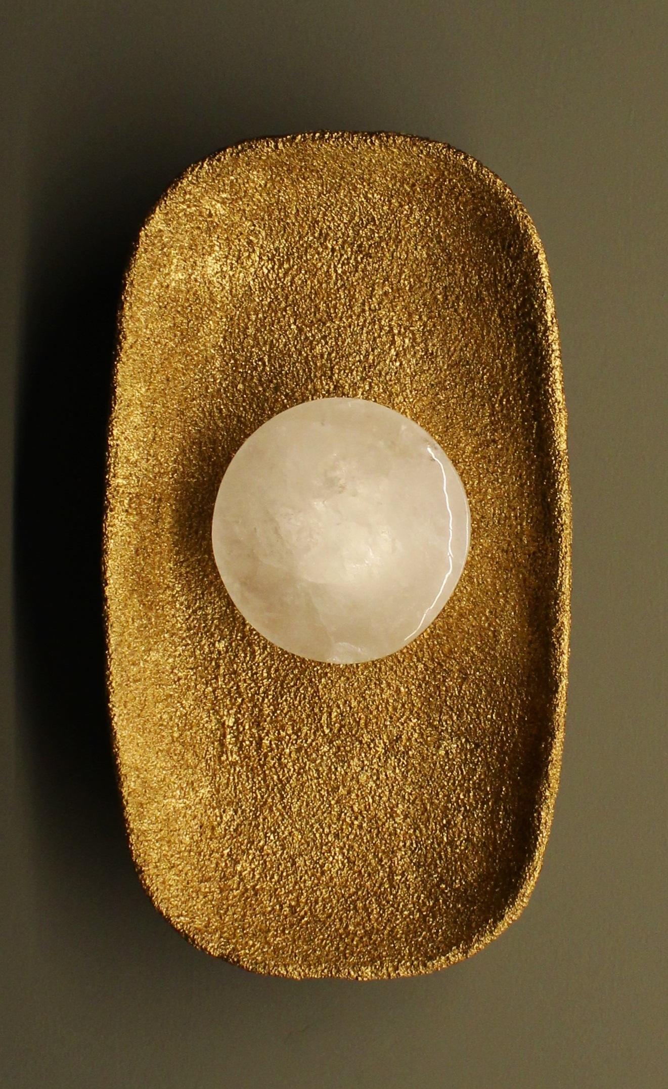 Moonlight Wall Sconce with White Quartz And Gold Patina Details by Aver
Dimensions: D 8 x W 21 x H 38 cm.
Materials: White quartz and patinated metal.

Available in different finishes. All our lamps can be wired according to each country. If sold to
