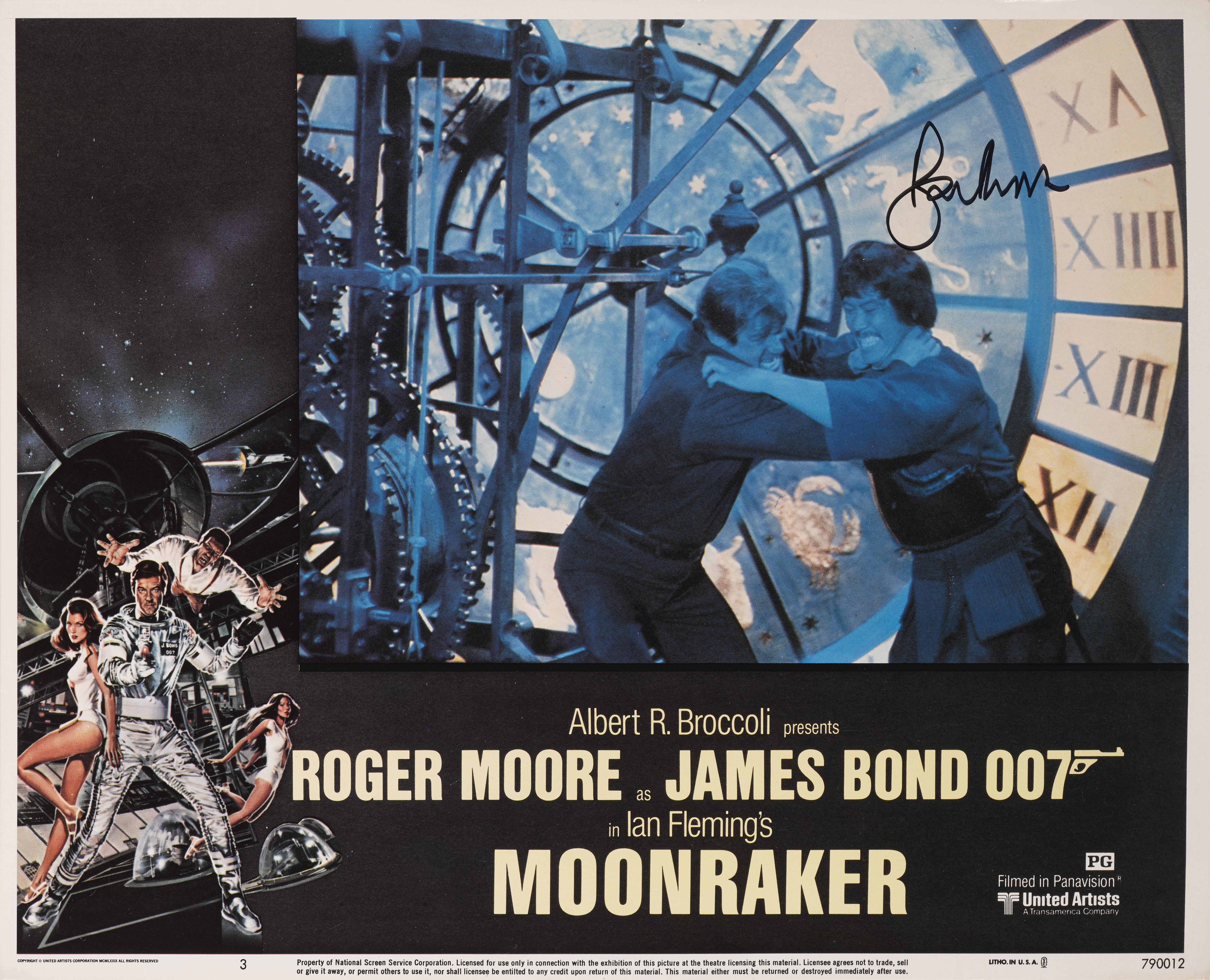 Original US-Lobbykarte für den James-Bond-Film Moonraker von 1979 mit Roger Moore als 007, Lois Chiles, Michael Lonsdale und Richard Kiel in den Hauptrollen. 
Diese Lobby-Karte ist von Roger Moore signiert.
Das Stück ist Erhaltung gerahmt mit gering