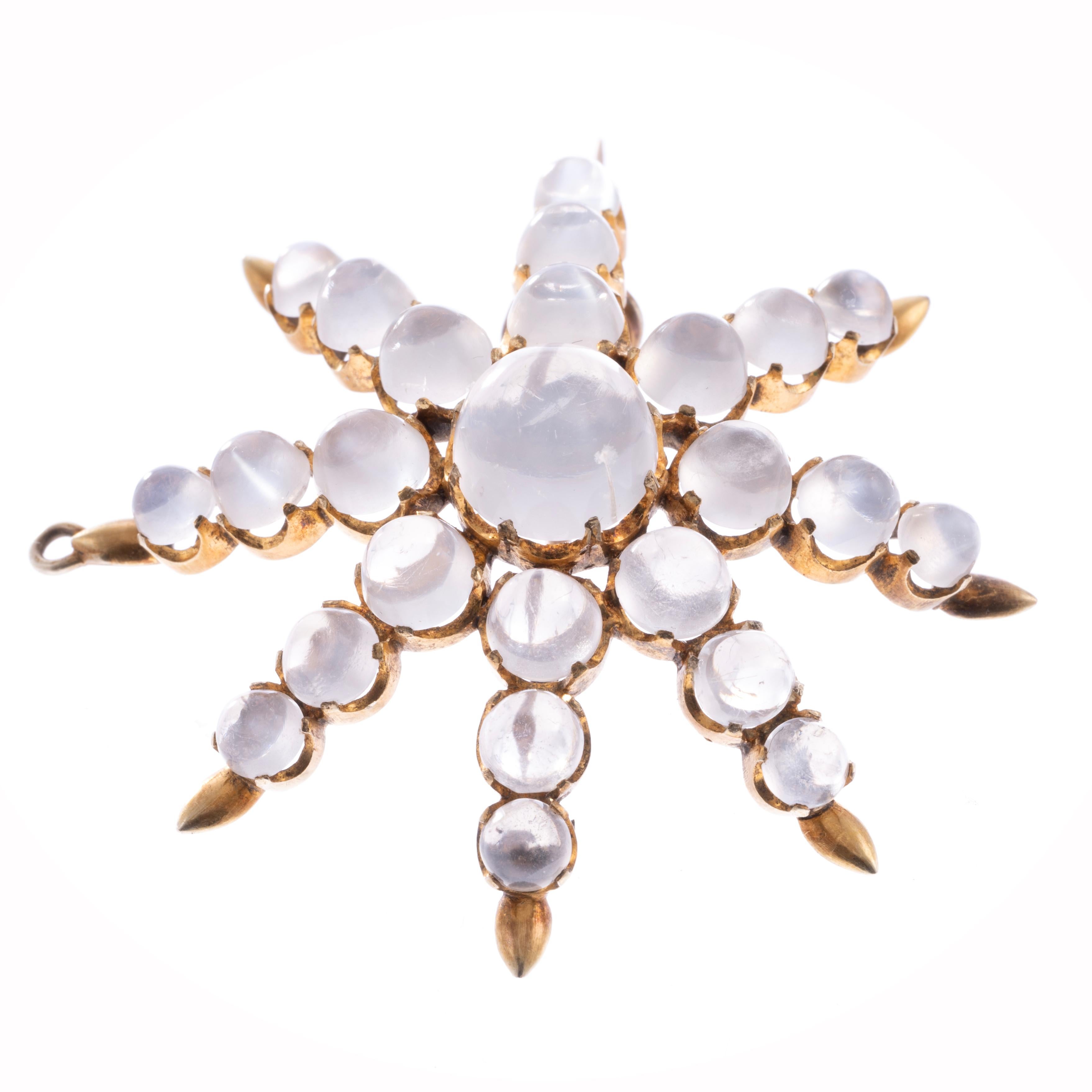 An alluring antique moonstone pendant and brooch combination circa 1860. Within a sea of glowing silver-flash cabochon moonstones, an exceptional center 4.00 carat moonstone gem perfectly blends into this subtle yet impactful jewel.  The