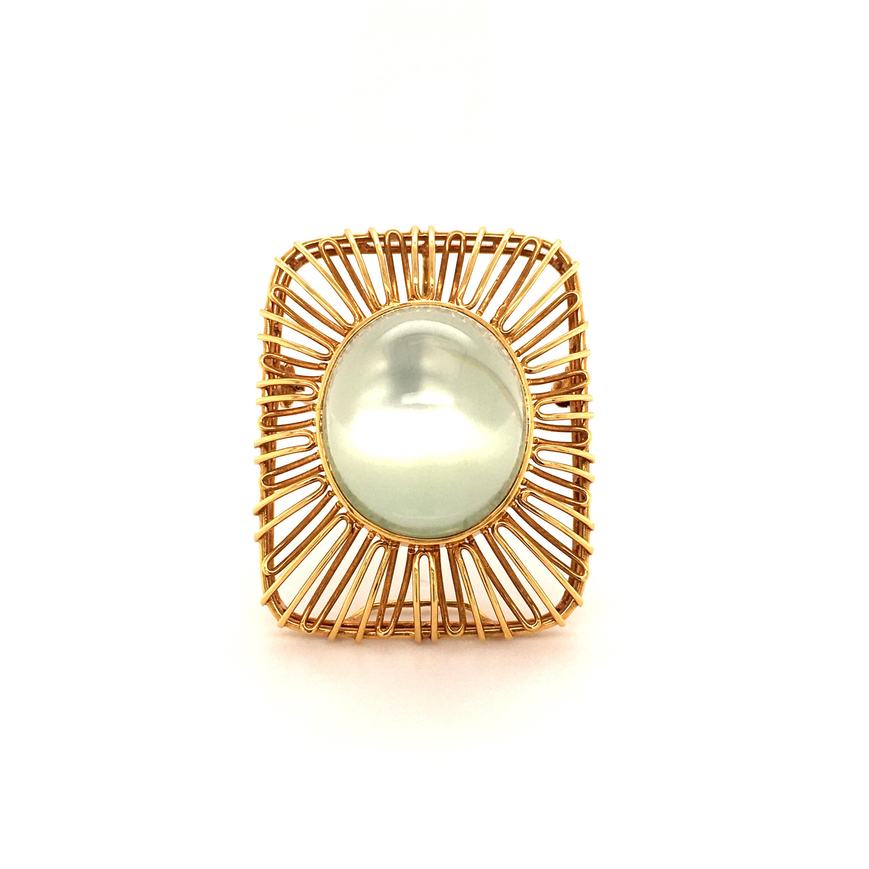 This mesmerizing light green moonstone cabochon of circa 40.00 carats is bezel set in a beautifully handcrafted brooch. Can also be worn as a pendant. 
Setting in 18 karat yellow gold.

Maker's mark: Merz
Hallmark: 750