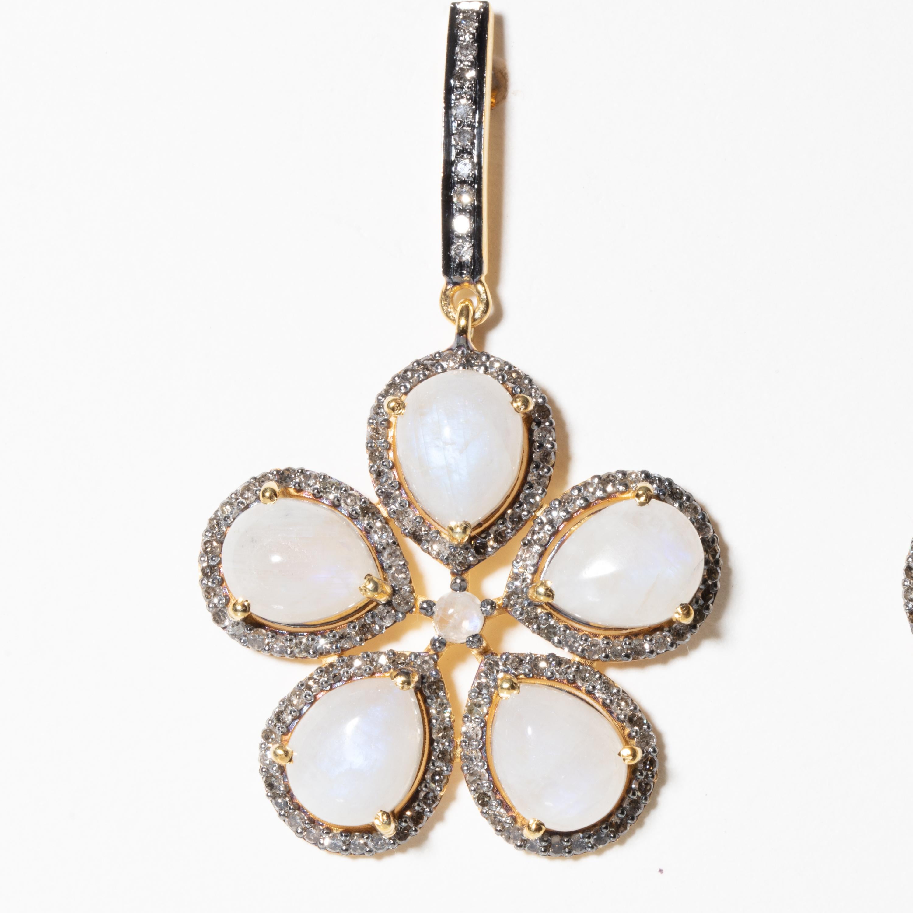 Pear-shaped cabochon moonstones bordered with pave`-set diamonds, and diamonds along the vertical post as well.  Small round cabochon moonstone at center.  Set in sterling silver with 18K gold post.  For pierced ears.  Weight of diamonds is 2.44