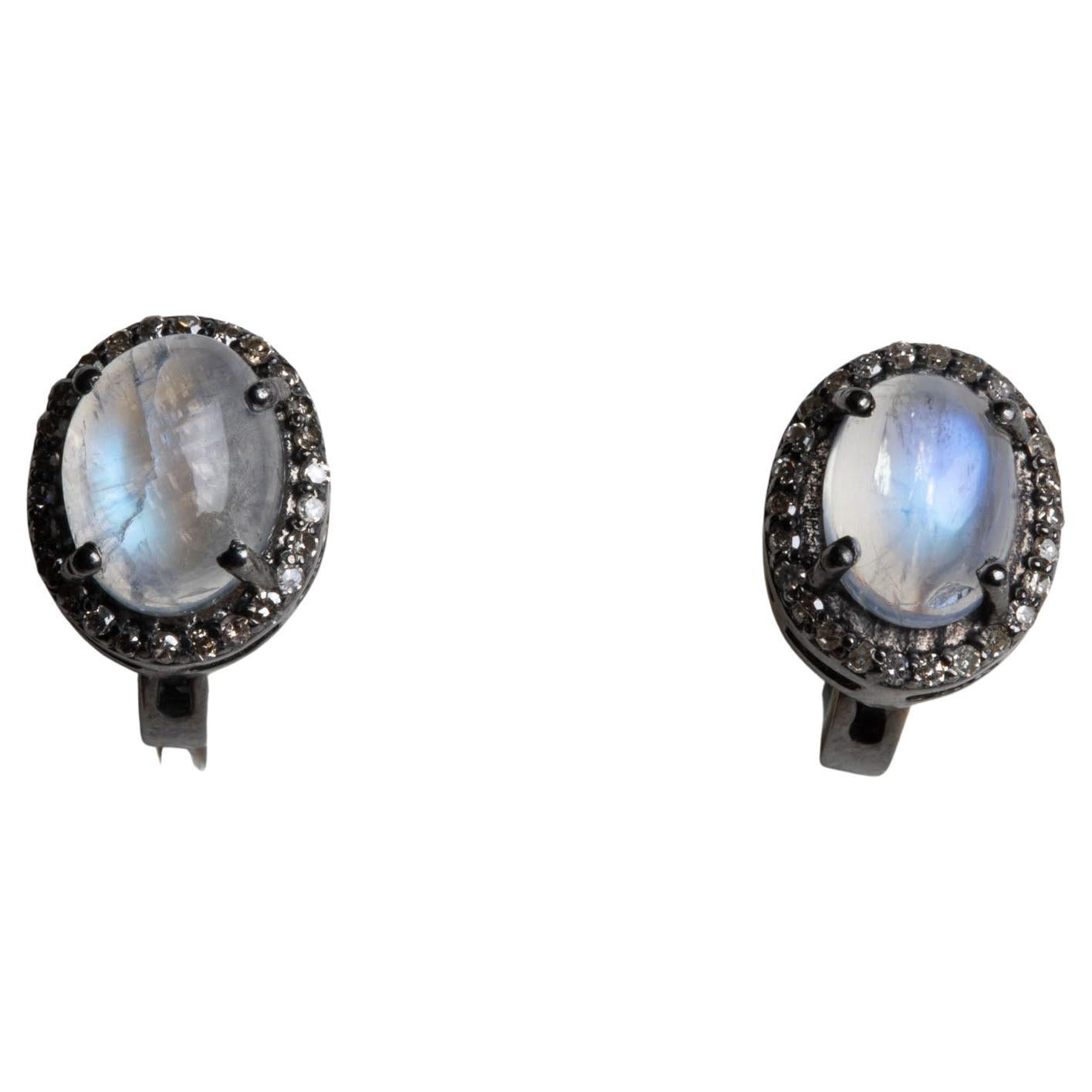 Large cabochon rainbow moonstones bordered by round-cut diamonds in a pave` setting in oxidized sterling silver.  Beautiful blue iridescence to the moonstones.  Diamonds total .32 carats, moonstones total 2.40 carats.  French clip for pierced ears.