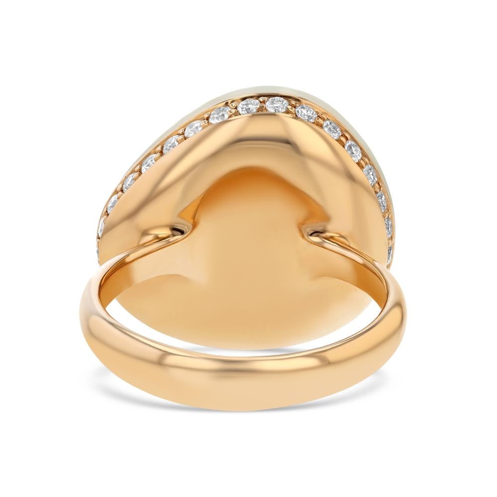 This ring is a beauty full of surprises. Upon first glance one will see a beautiful organic shaped moonstone center set in 18 karat rose gold. However, upon turning the ring the glistening of a row of prong set diamonds that cover the rose gold