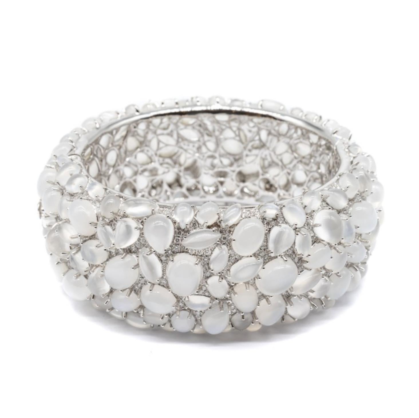 A moonstone and diamond bangle bracelet, set with one hundred and ninety cabochon-cut moonstones weighing an estimated total of 138.45ct, and five hundred and seventy-four pavé set round brilliant-cut diamonds weighing an estimated total of 4.84ct,