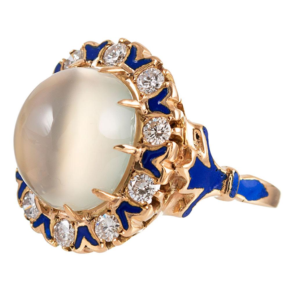 A 6 carat cabochon of moonstone is framed by round white diamonds (.75 carats in total) and accented with intense royal blue enamel. The combination is unusual and entirely symbiotic! Note the “fleur de lys” style detail on the sides and the subtle