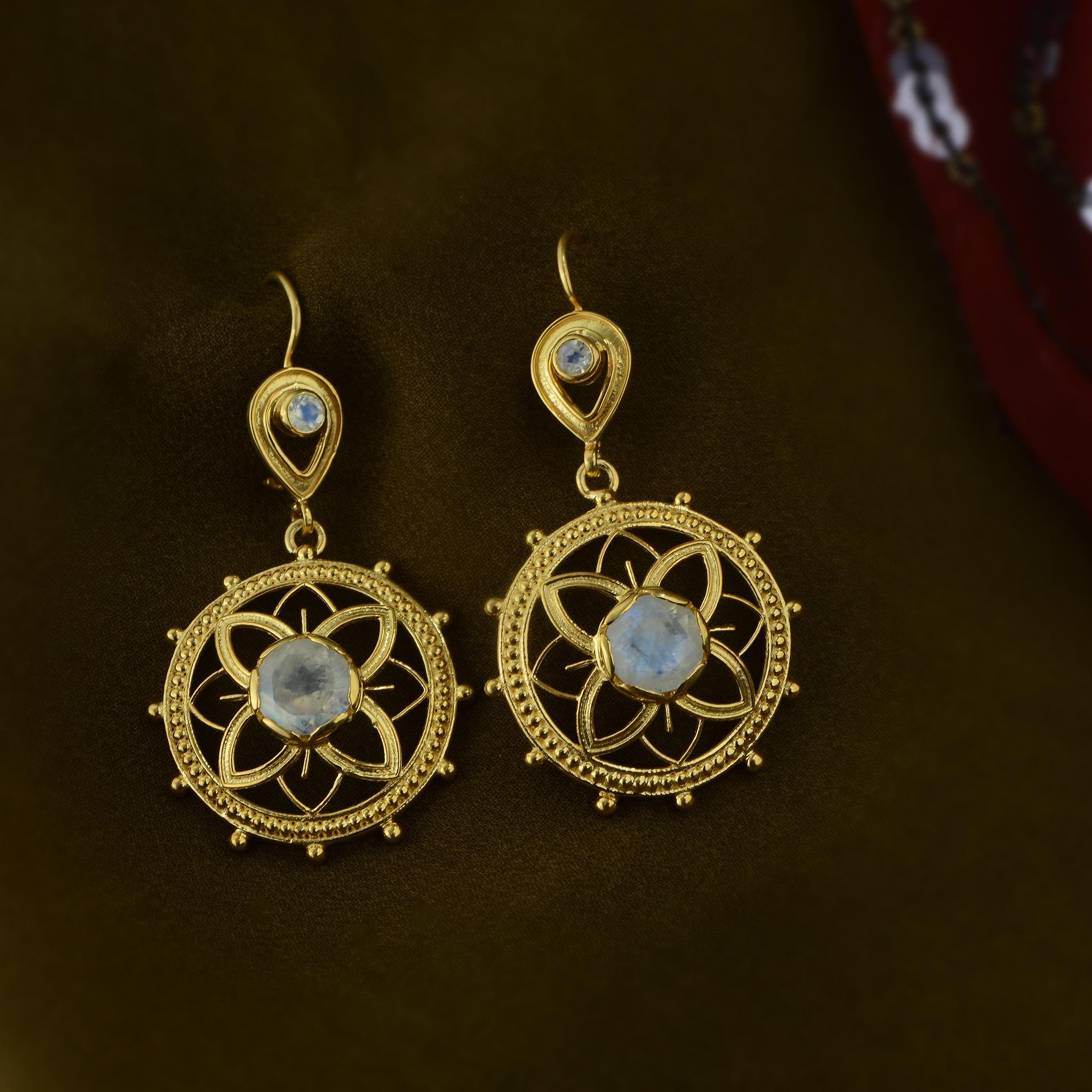 

These beautiful moonstone dangle earrings have been handmade in our workshops. We have used jaali,  embossed and hand engraving work and embedded them with rainbow moonstones. The earrings are made in sterling silver coated with 24ct gold vermeil