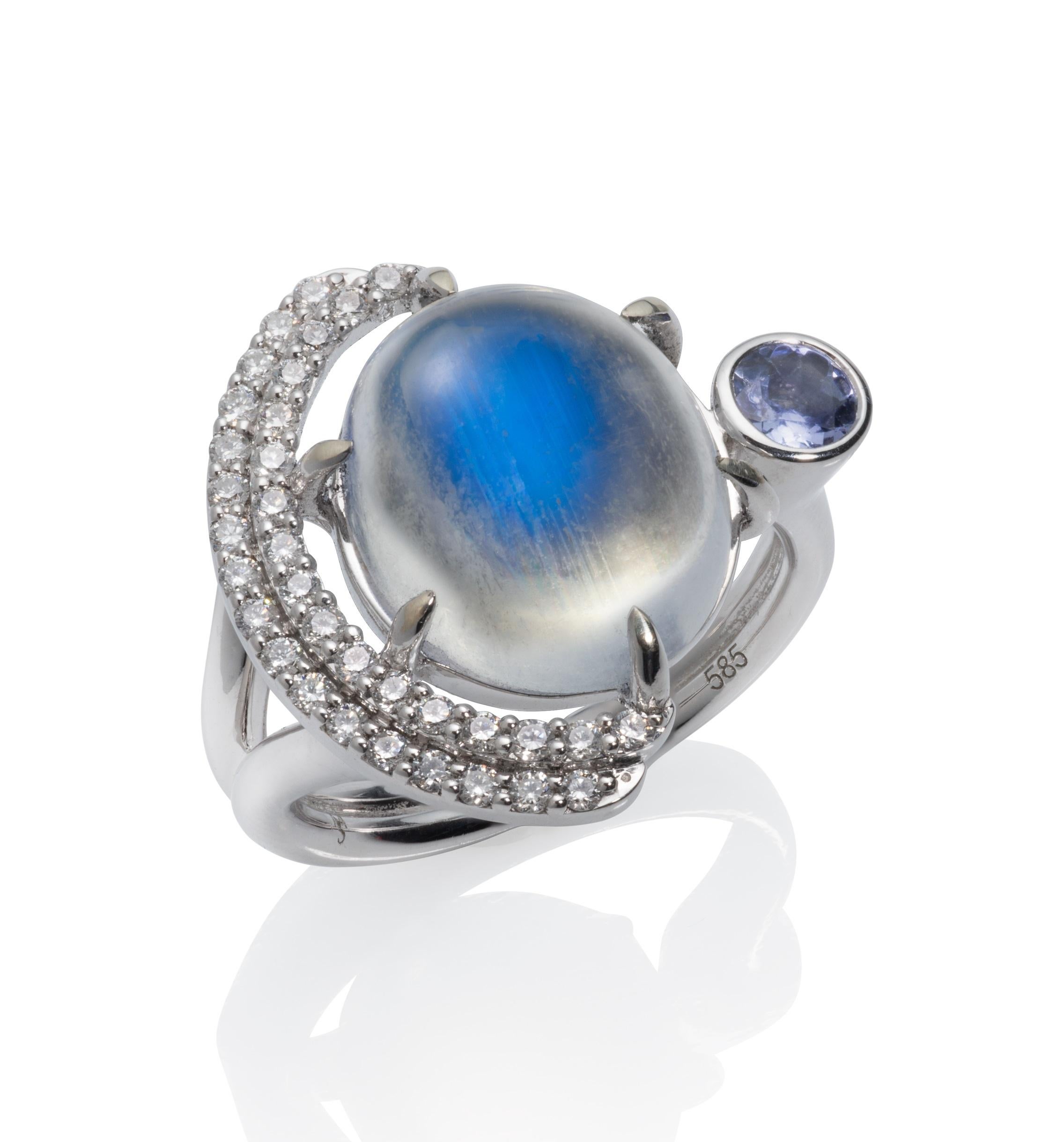 The Eclipse cocktail ring from the Blue Hour collection has many variations, but this one is made in 14kw gold with an included 14 x 12.5 mm oval  Blue Sheen moonstone, 31- 1.3mm  round, white diamonds and a  4mm (.5 ct) round, pale purple