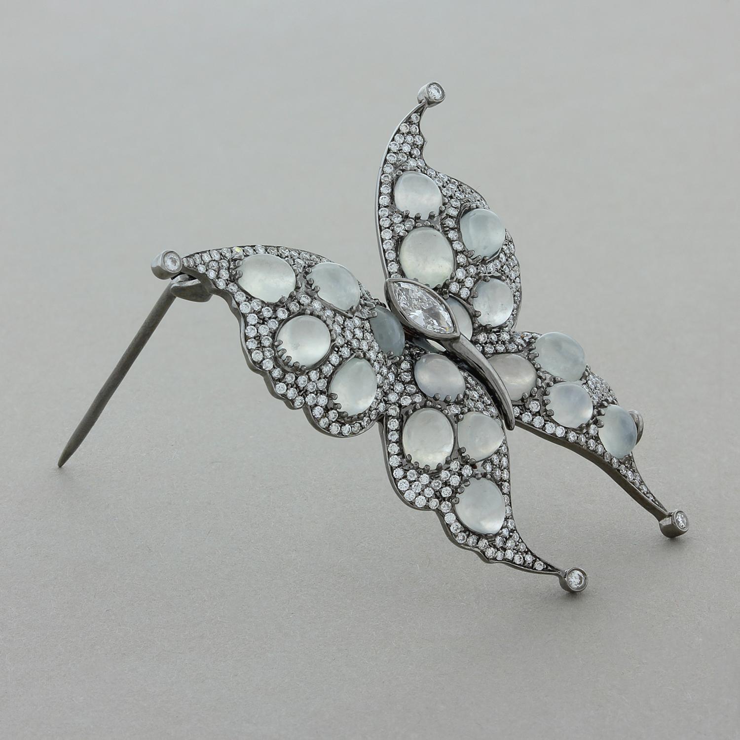 A spectacular butterfly brooch polka dotted with 8.90 carats of moonstone which show flashes of blue as they move in the light. The cabochon moonstones are accented by round cut diamonds and a single marquise cut diamond, totaling 1.38 carats. Set