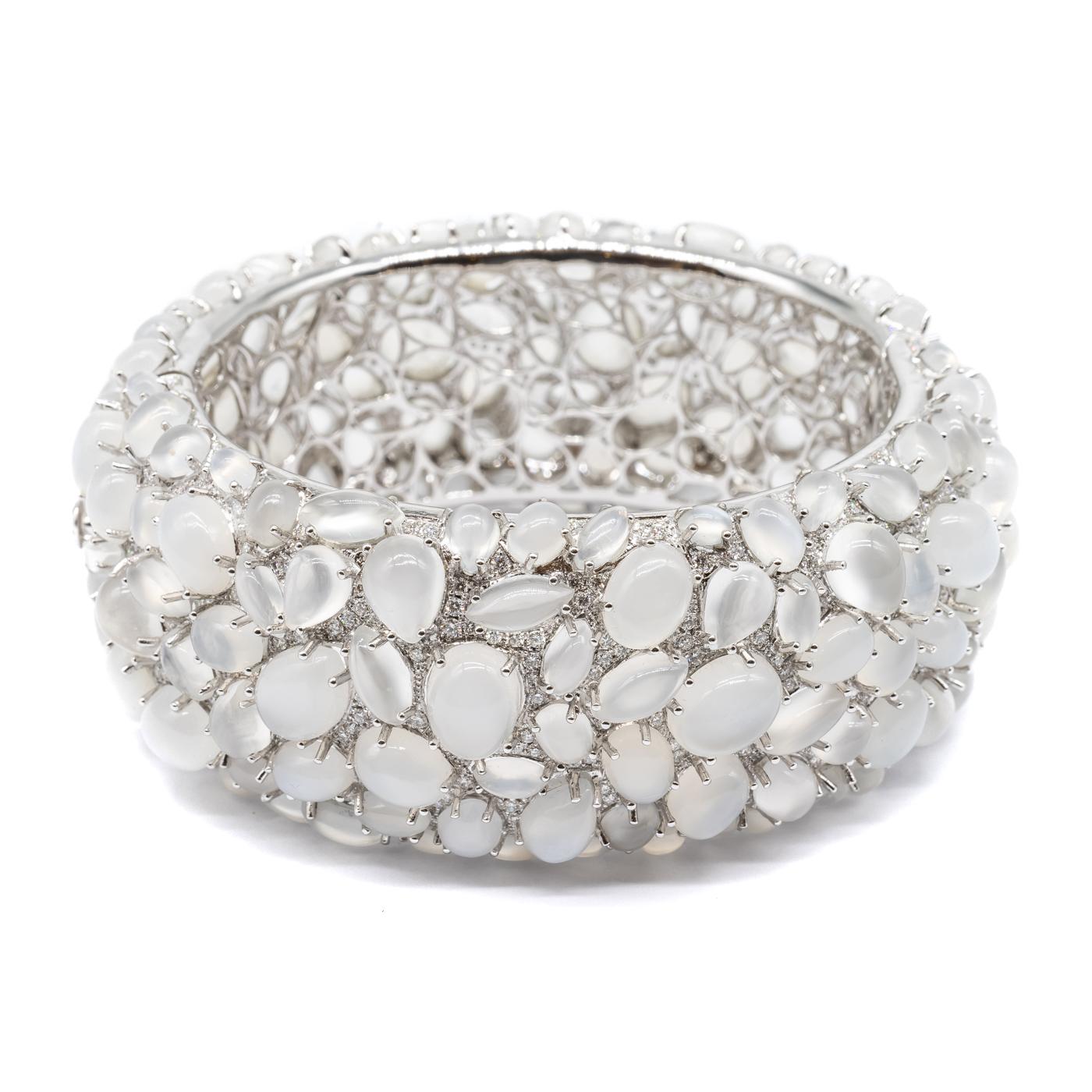 A moonstone and diamond bangle bracelet, set with cabochon-cut moonstones, weighing an estimated total of 138.45ct, and pavé set round brilliant-cut diamonds, weighing an estimated total of 4.84ct, mounted in 18ct white gold.