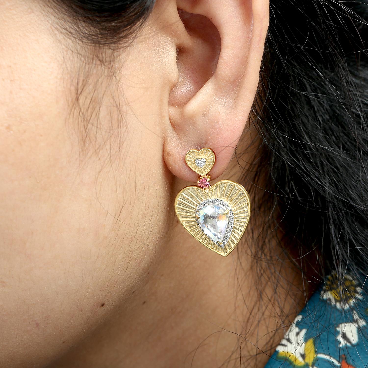 Romantic heart-shaped moonstones radiate a soft, dreamy glow, accented with delicate tourmalines and sparkling diamonds. Crafted in 14k gold, these dangle earrings offer a statement look that blends charm with elegance.

Metal Details
14k
