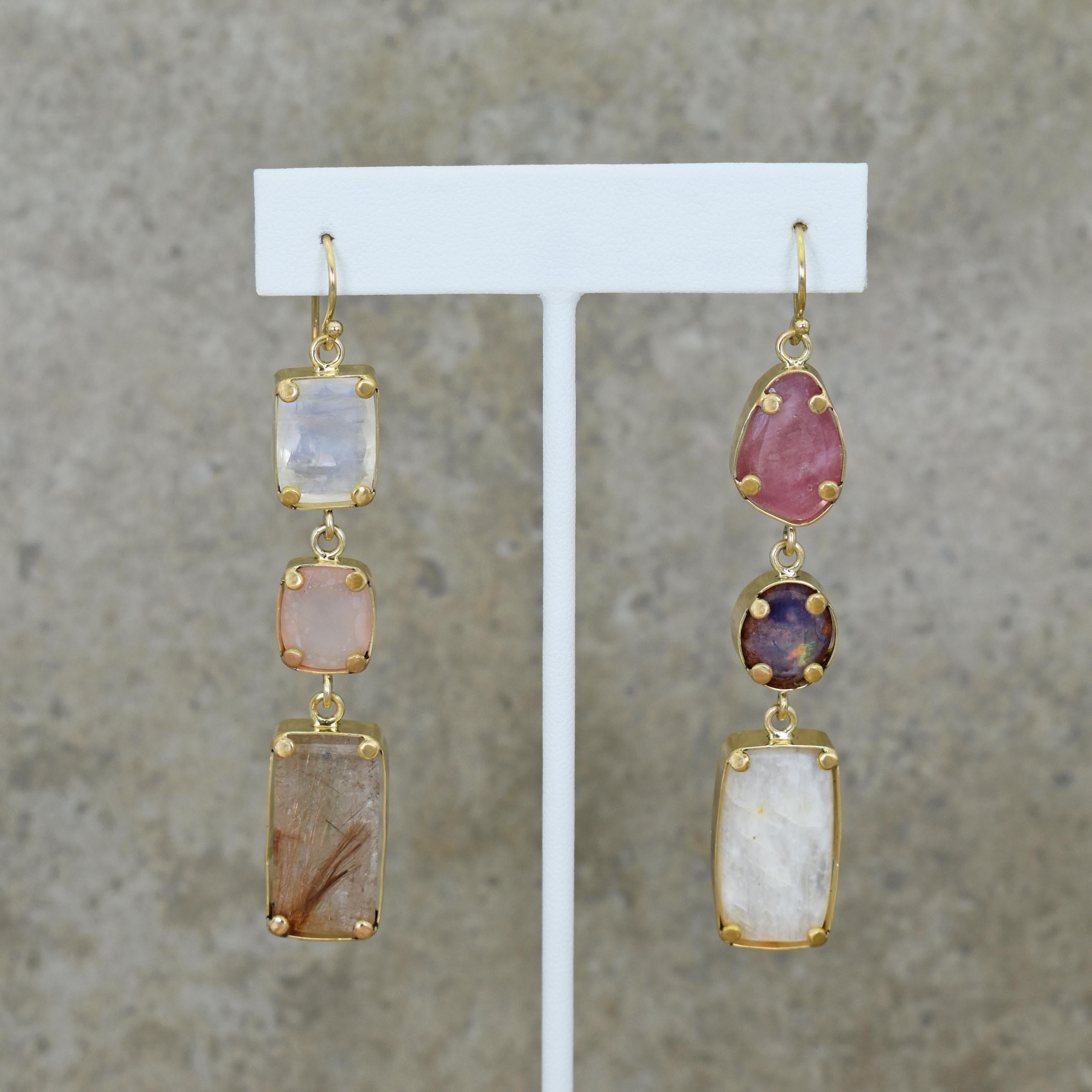 Contemporary 18k yellow gold asymmetrical dangle earrings featuring faceted Moonstone, Pink Chalcedony, Rutilated Quartz, Pink Tourmaline, Mexican Fire Opal and a Russian Moonstone cabochon. Dangle earrings are 3.13 inches in length. Gorgeous and