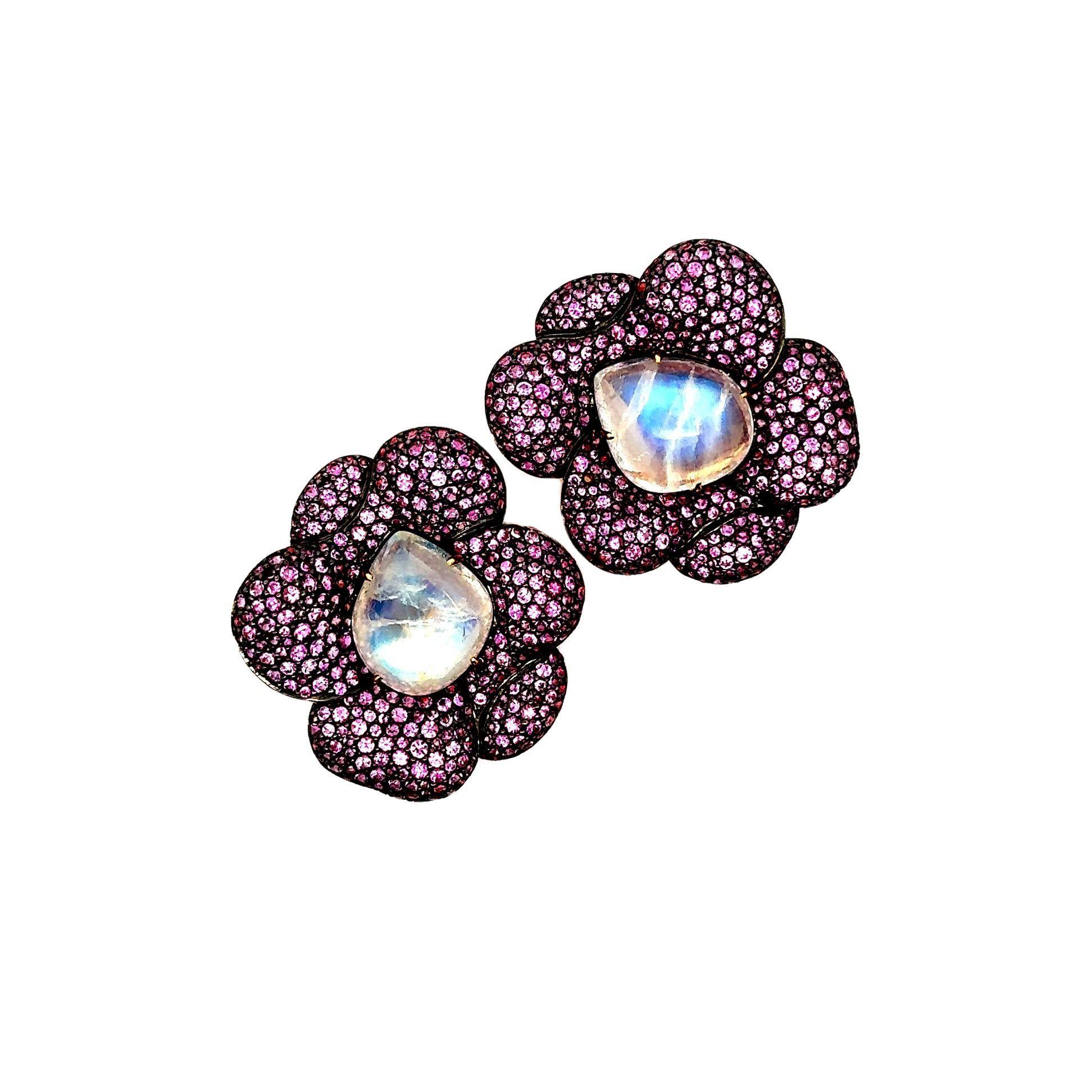 Crafted in 18k rose gold, these striking earrings are a captivating addition to any collection. Featuring 12.40 carats of luscious moonstones with strong billowy blue iridescence rolls across the stones surface. The design is enhanced by 10 carats