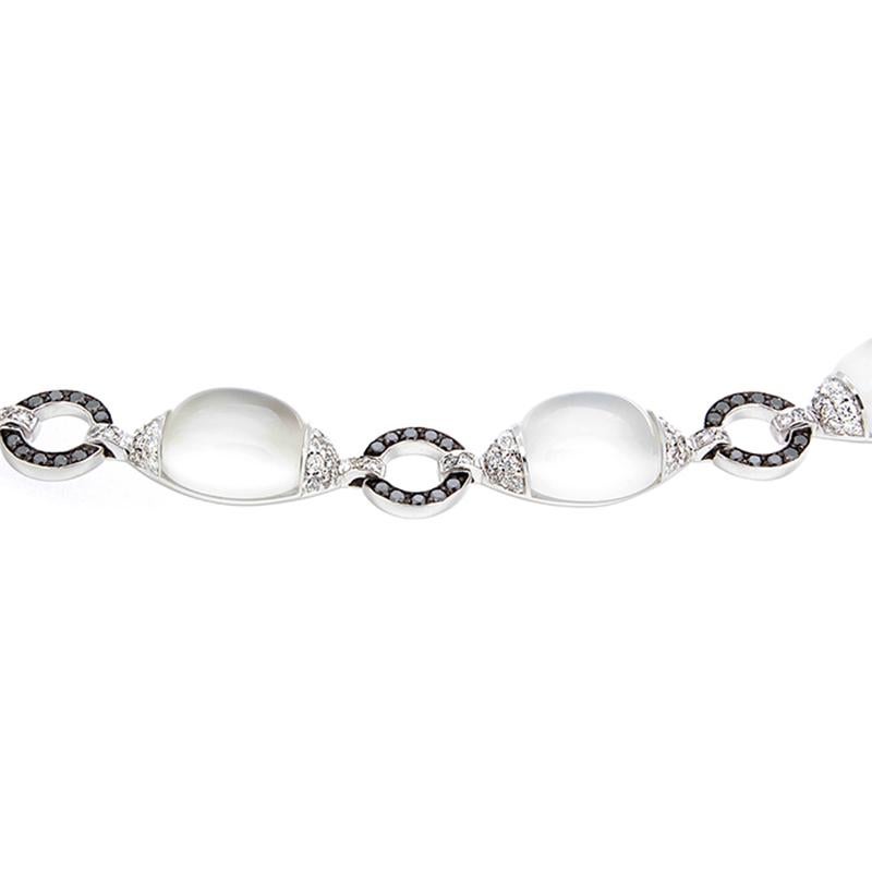 This unique bracelet features 49.18 carats of white cabochon moonstones accented by 2.04 carats of white round cut diamonds. A circle of 1.20 carats of black diamonds links each moonstone. The black diamonds are prong set in black gold and the rest
