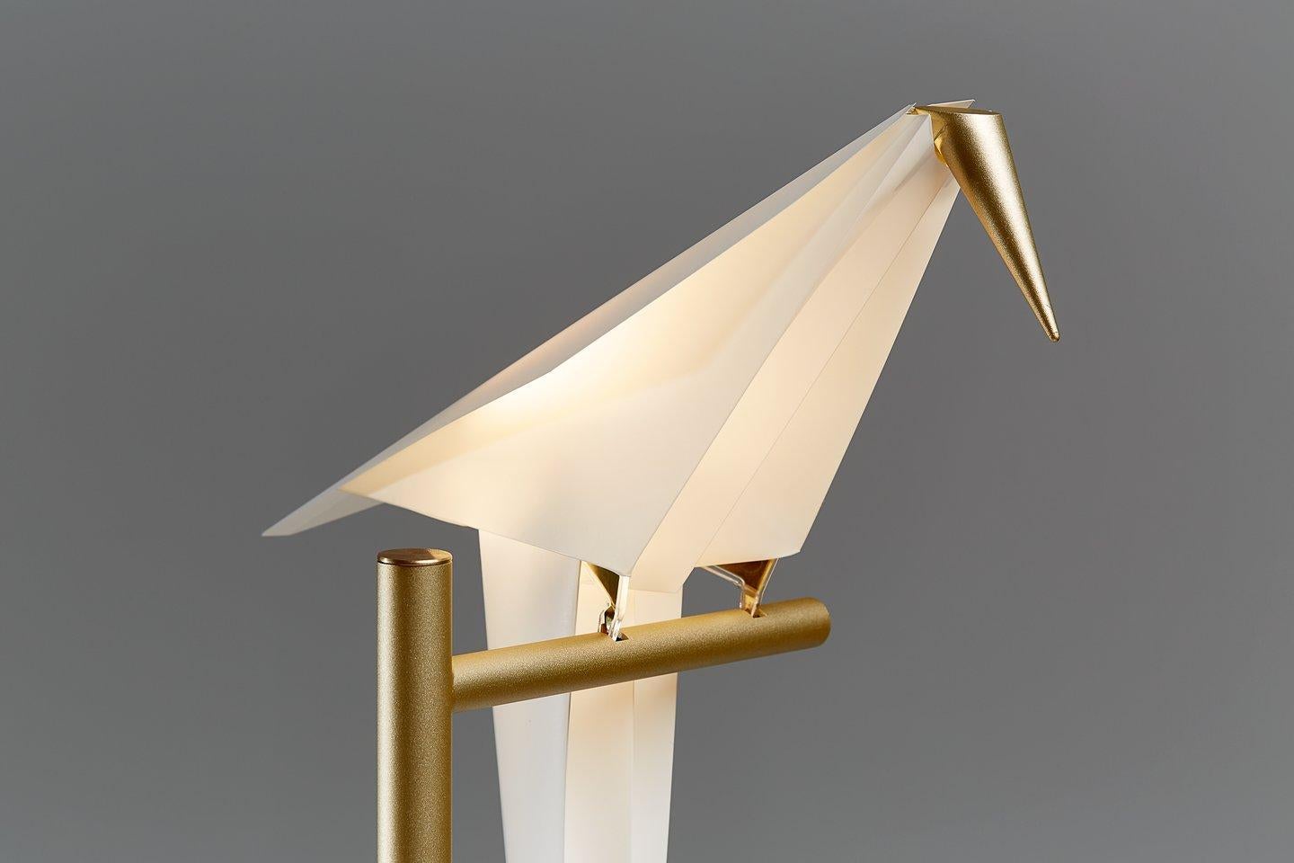 The Perch Light Table Lamp, the smallest of its family, holds its own particular charm. You may admire the details of its delicate beauty and follow the light swinging of the bird from nearby, while comfortably seated. What’s more, you can easily