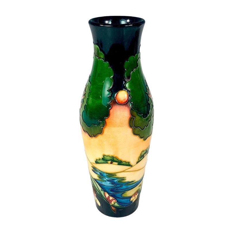 Exquisite vessel featuring tube-line decorations of the perfect sunset amidst the serene forest
A Moorcroft pottery vase in the Evening Sky pattern, designed by Emma Bossons, impressed mark verso and dated 2003, (silver line through EB