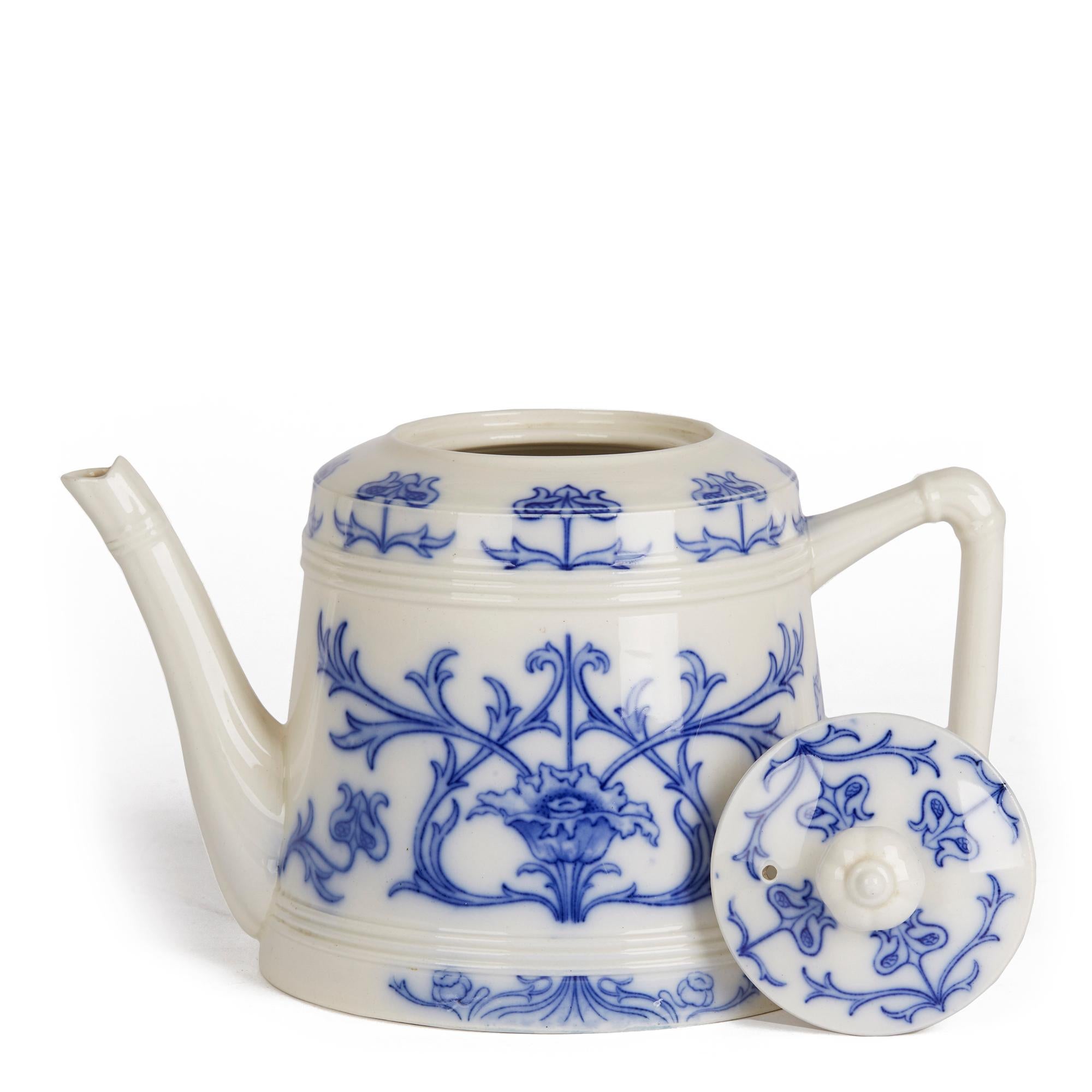 A rare and early blue and white Art Nouveau Aurelian ware teapot and cover of rounded cylindrical shape with moulded shaped handle and shaped spout with a recessed cover. The teapot has typical period designs with floral buds and flowers set with