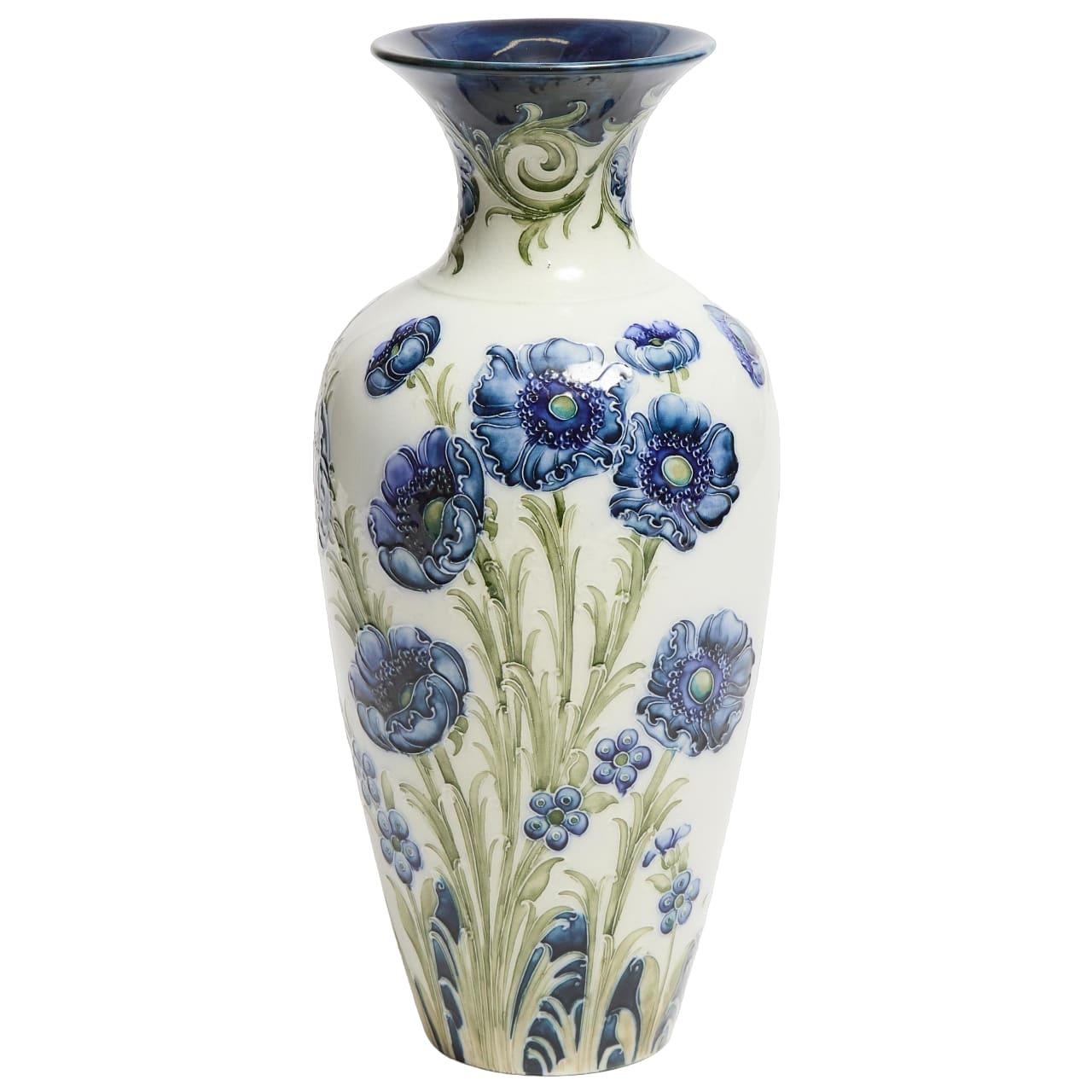 A William Moorcroft Macintyre 'Poppy' design vase
Circa 1902
Of baluster form with flared neck rim, the body decorated with blue poppies, 30 cm high, printed Macintyre factory mark, green painted W. Moorcroft des. RN401753
Good professional