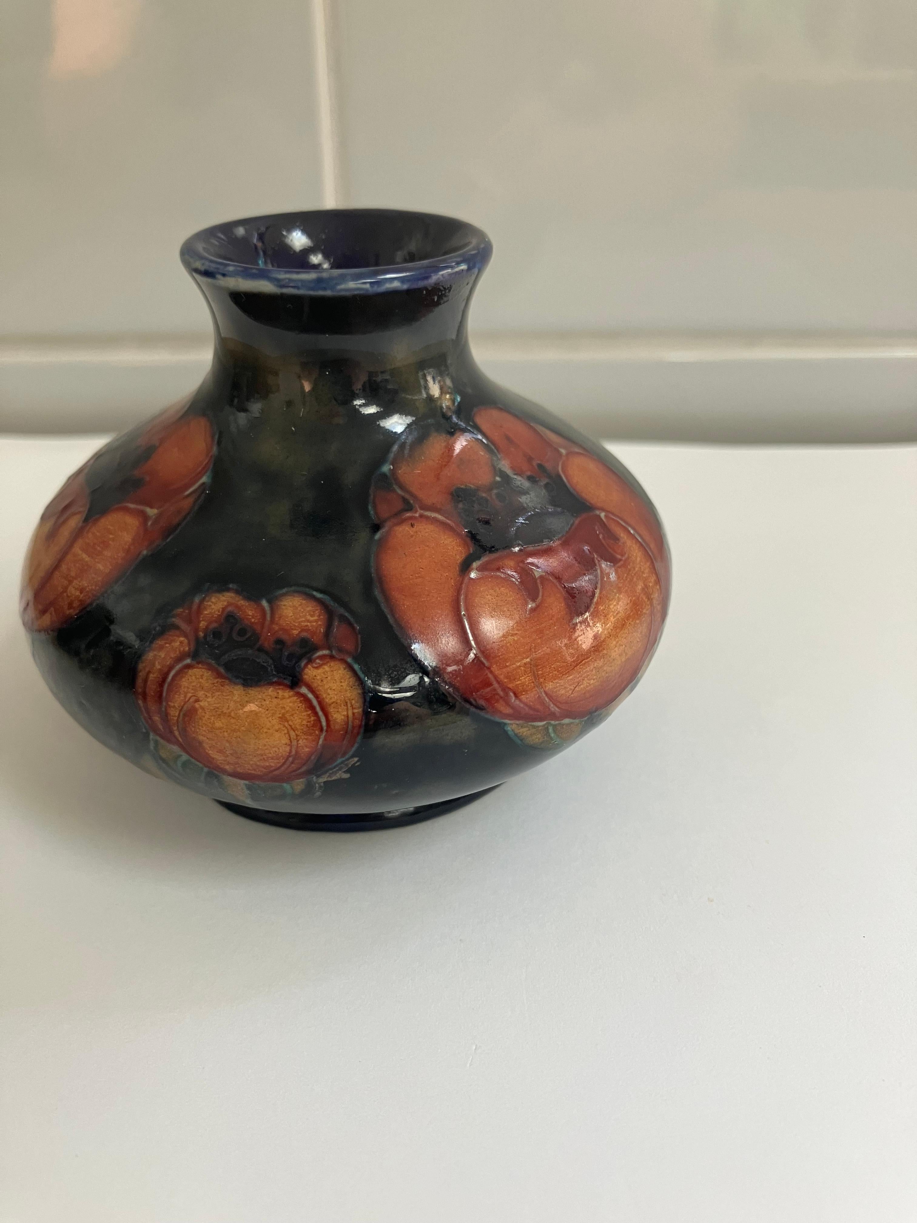 Questo grazioso vaso inglese vintage è opera di William Mooorcroft, Burslem, Inghilterra. Il vaso presenta il motivo del papavero su un fondo blu cobalto e papaveri rossi, firma di Moorcroft. Il pezzo è firmato e i segni impressi sulla base
