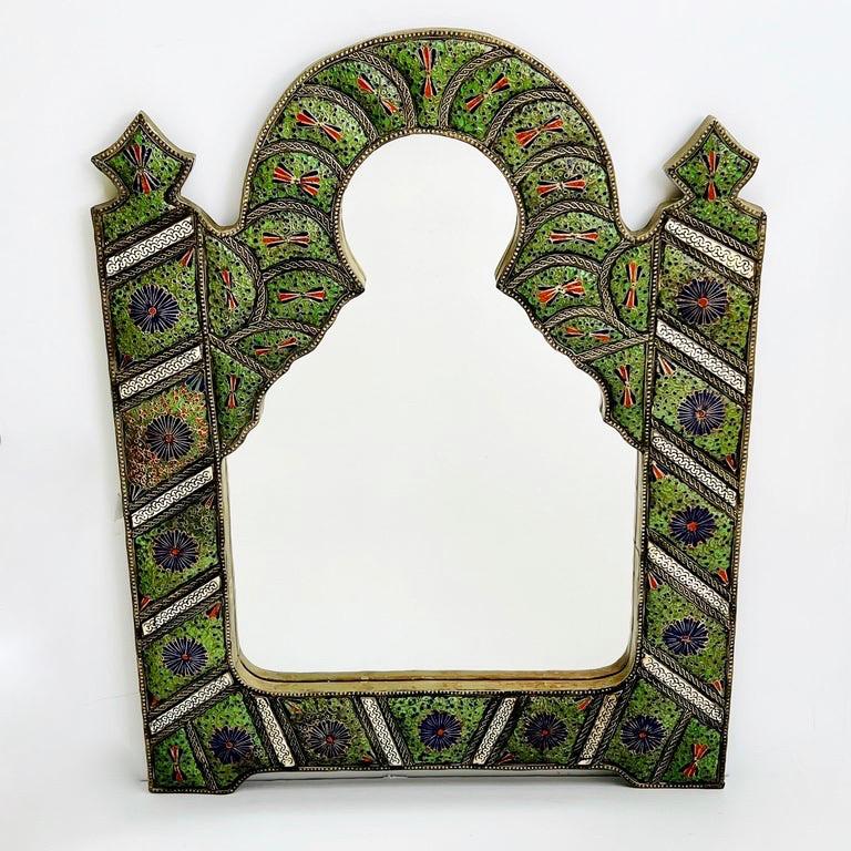 Moroccan Moorish mirror with keyhole design.  This vintage mirror has an arched design comprised of decorative Cloisonné, an enamel made from glass, porcelain, and gemstones on metal backing and separated by wire, creating a unique mosaic design in