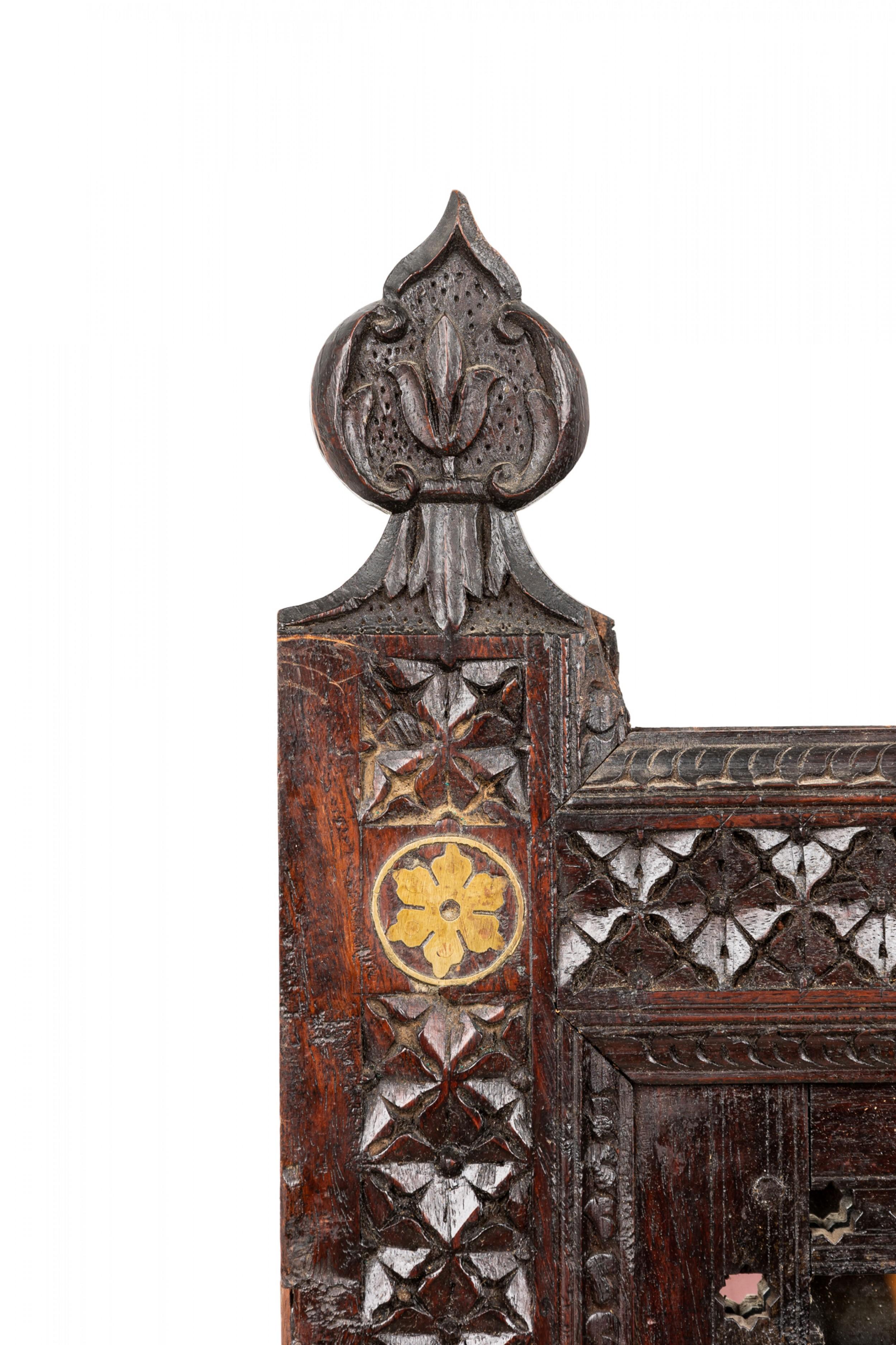 Middle Eastern Moorish style (19th Century) carved teak wall panel with a large brass inlaid center panel centered between a mirrored top panel and filigree bottom panel.