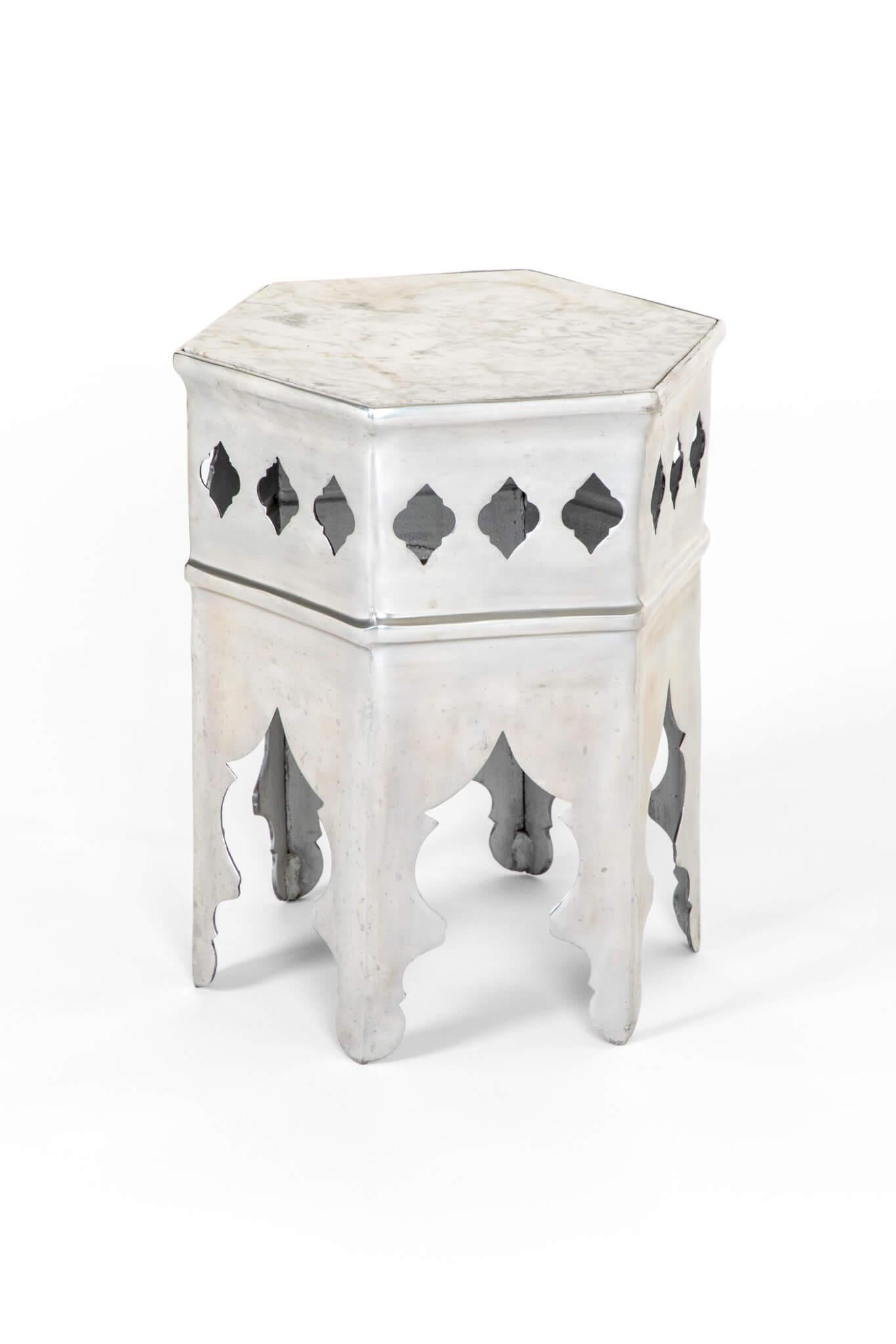 A hexagonal Moorish style side table in heavy gauge polished steel with  a white marble insert.

Curved arch supports to the six sturdy legs and completed with a diamond symmetrical frieze.

A wonderful piece of design ready for every day