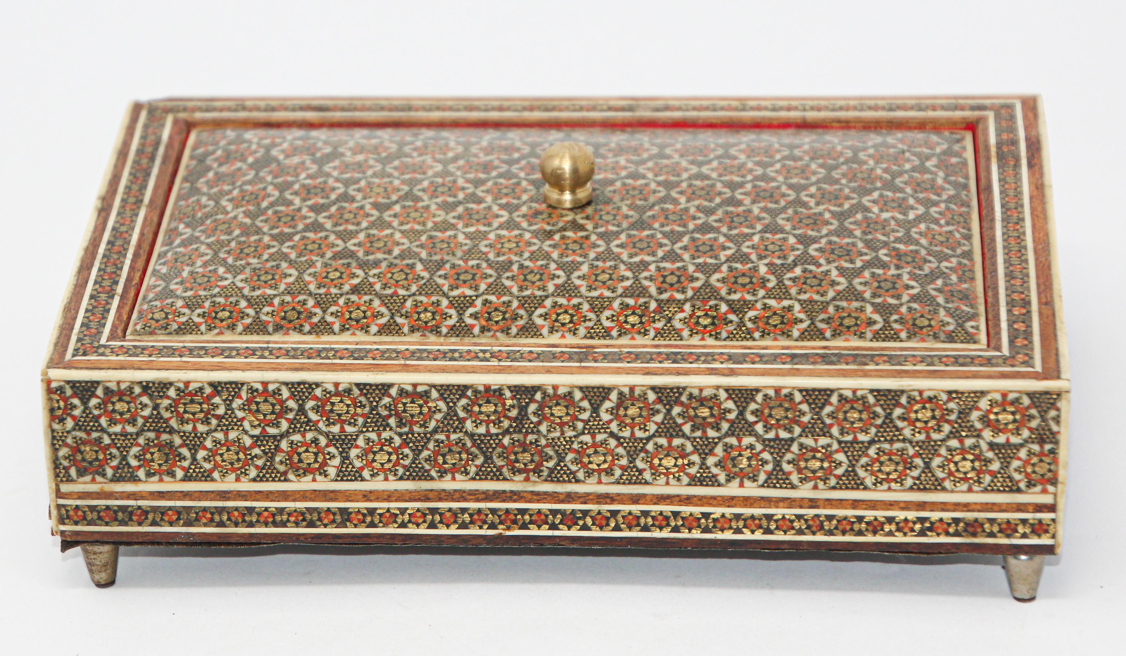 Middle Eastern Sadeli micro mosaic inlaid jewelry footed box with lid.
Intricate inlaid box with floral and geometric Moorish design.
Sadeli micro mosaic designs in mosaic marquetry, very fine artwork.
Lined with red velvet and glass, top final and