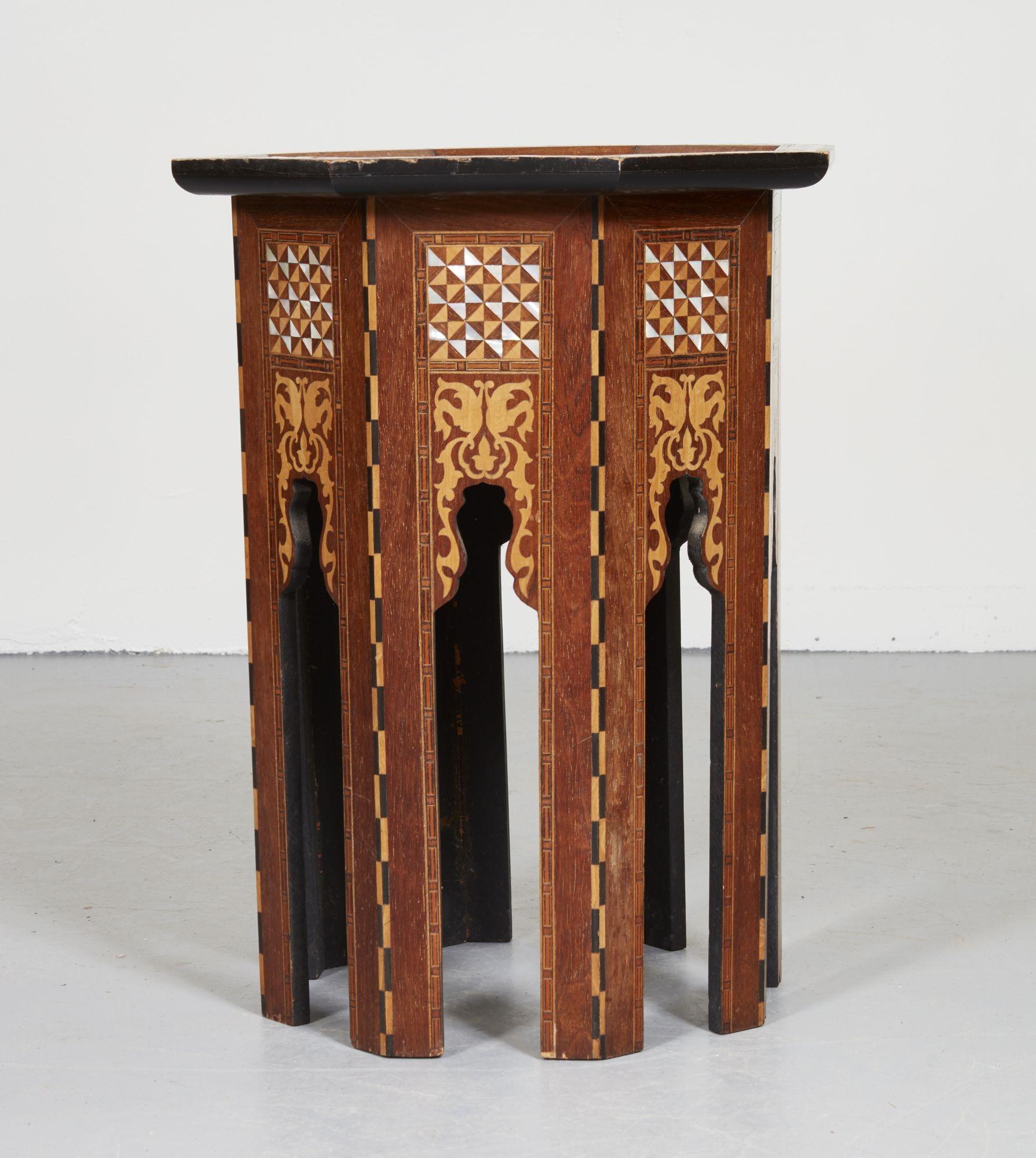 A drinks table in the Moorish style with an octagonal top and faceted octagonal base with arched colonnaded legs having intricate marquetry, inlay and mother of pearl geometric decoration. In the manner of Libertys of London.