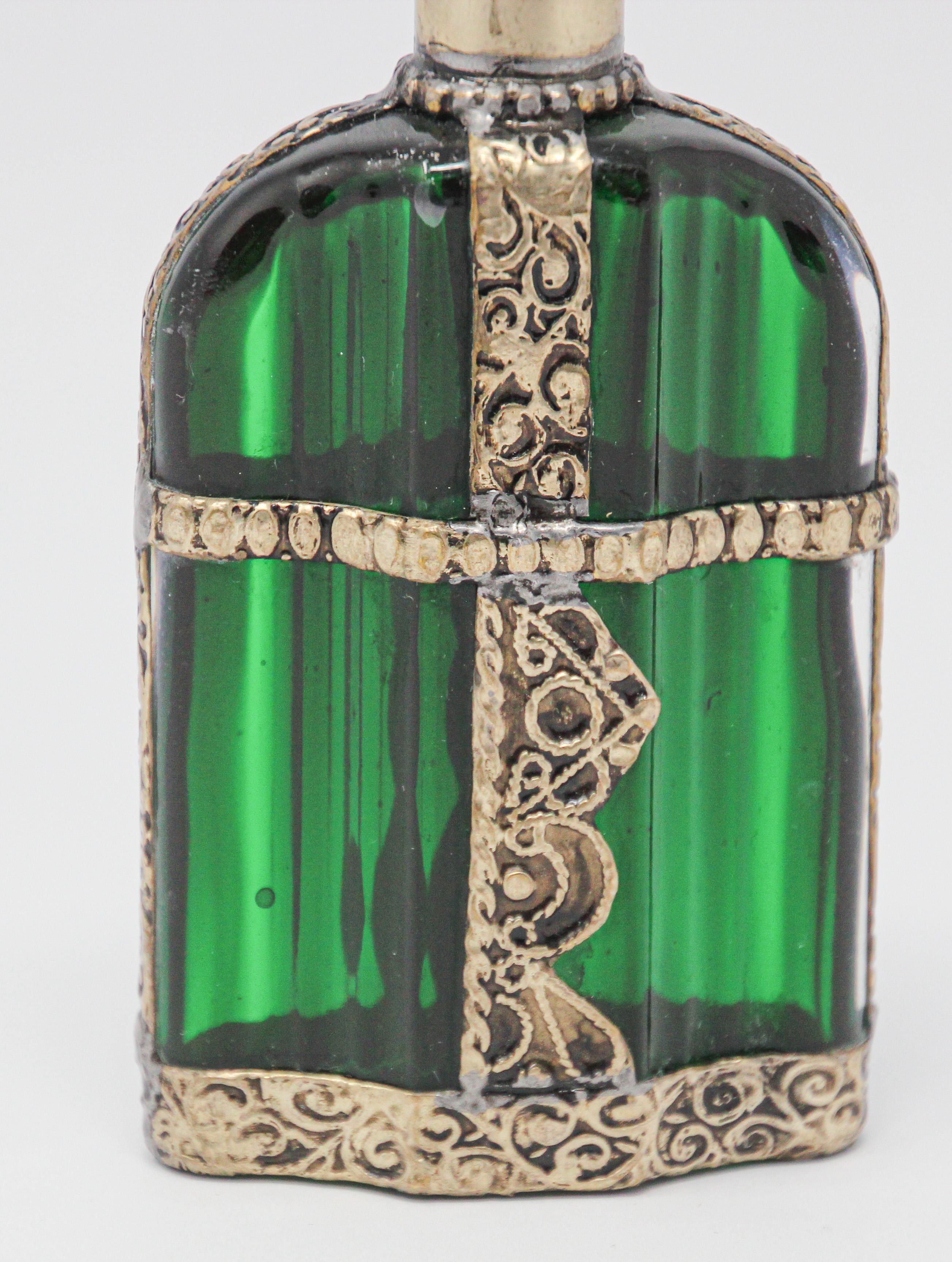 Handcrafted Moroccan Moorish Emerald green painted glass perfume bottle or rose water sprinkler with raised embossed silvered metal floral design over glass.
The pressed glass bottle in Art Deco, Art Nouveau style is oval shape with curved sides and