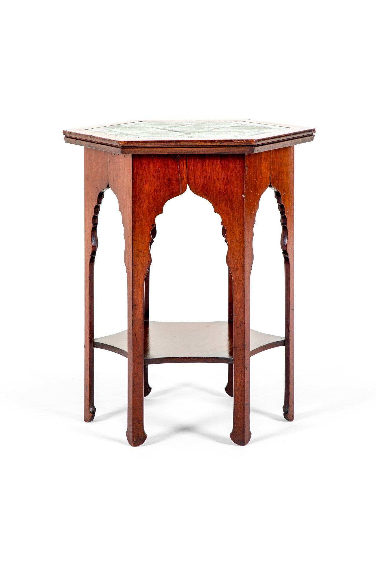 A splendid Moorish style hexagonal occasional table made of mahogany.

The top is inlaid with a geometrical pattern of two tone emerald coloured tiles offering a perfect juxtapose to the mahogany base.

Beneath the top a series of six horse shoe