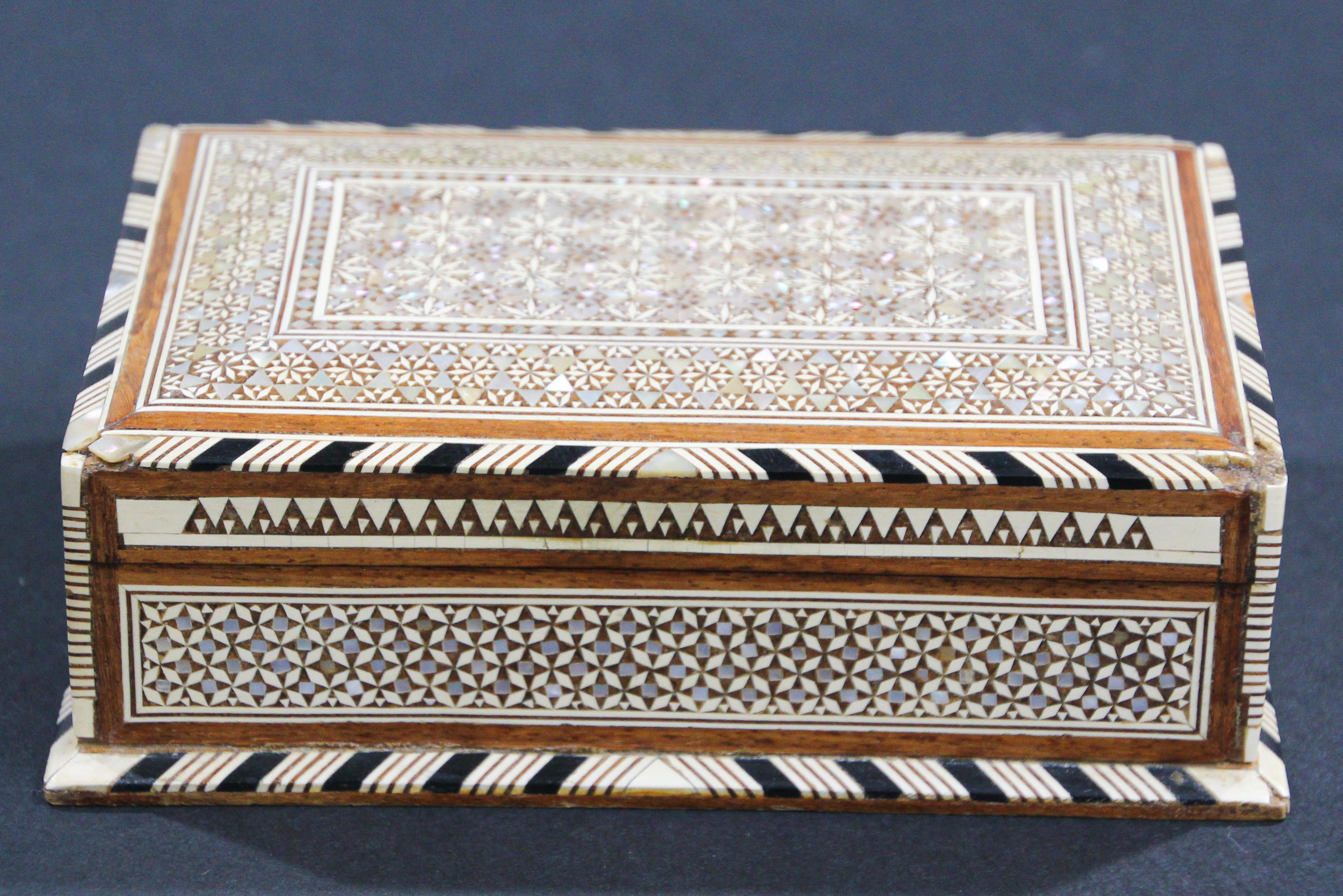Exquisite handcrafted Middle Eastern mosaic marquetry inlaid walnut wood box.
Large box intricately decorated with Moorish motif designs which have been painstakingly inlaid with mosaic marquetry, mother of pearl and fruitwoods.
Middle Eastern,