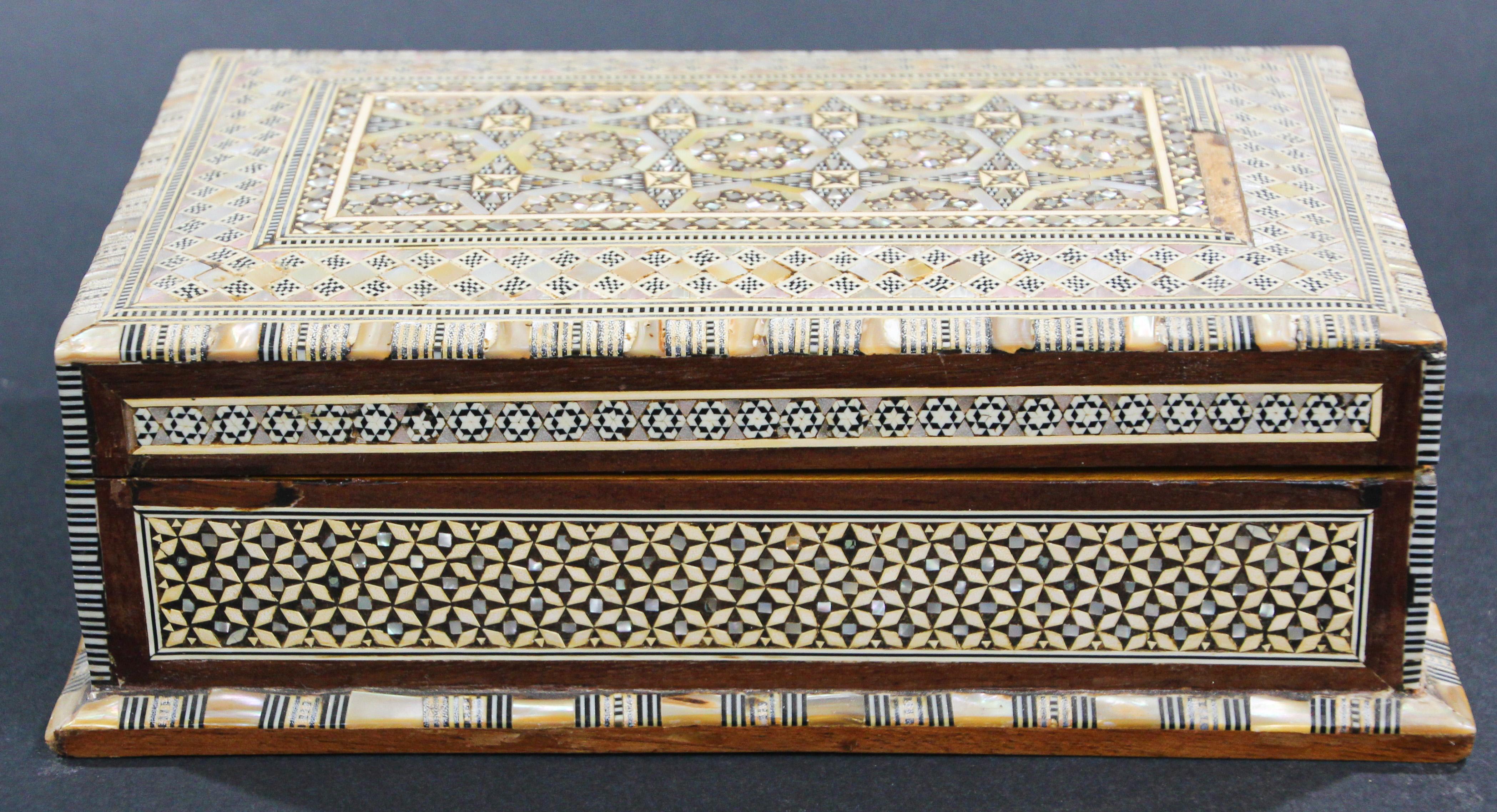 Exquisite handcrafted Middle Eastern mosaic marquetry inlaid walnut wood Jewelry box.
Large box intricately decorated with Moorish motif designs which have been painstakingly inlaid with mosaic marquetry, mother of pearl and fruitwoods.
Middle