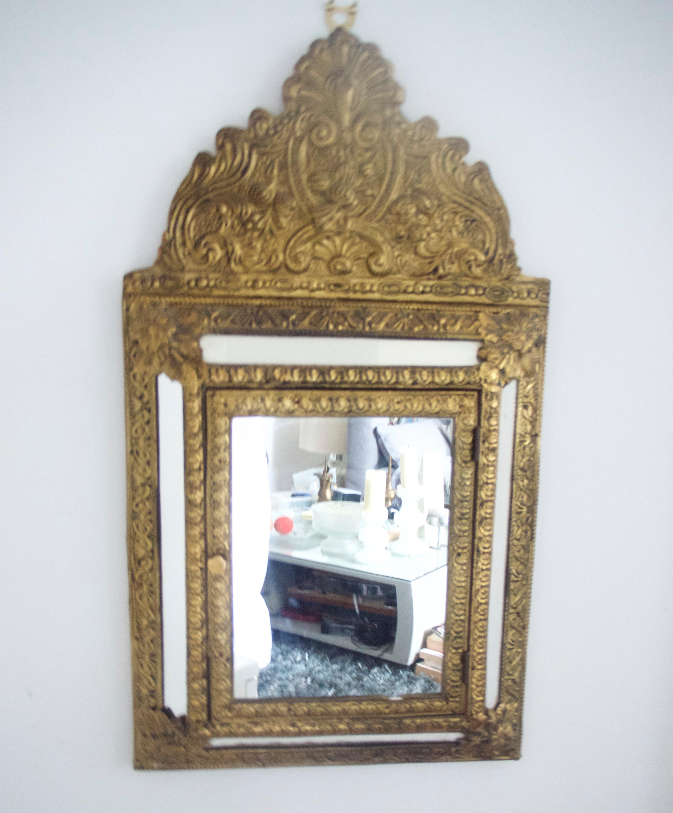'Moorish Middle Eastern' style beaten brass wall-mounted mirrored box, UK, 1955
These pieces originally housed clothes and shoe brushes (hence the cup hooks to the interior of the box and polish.

The mirror has a slight mark on it commensurate with